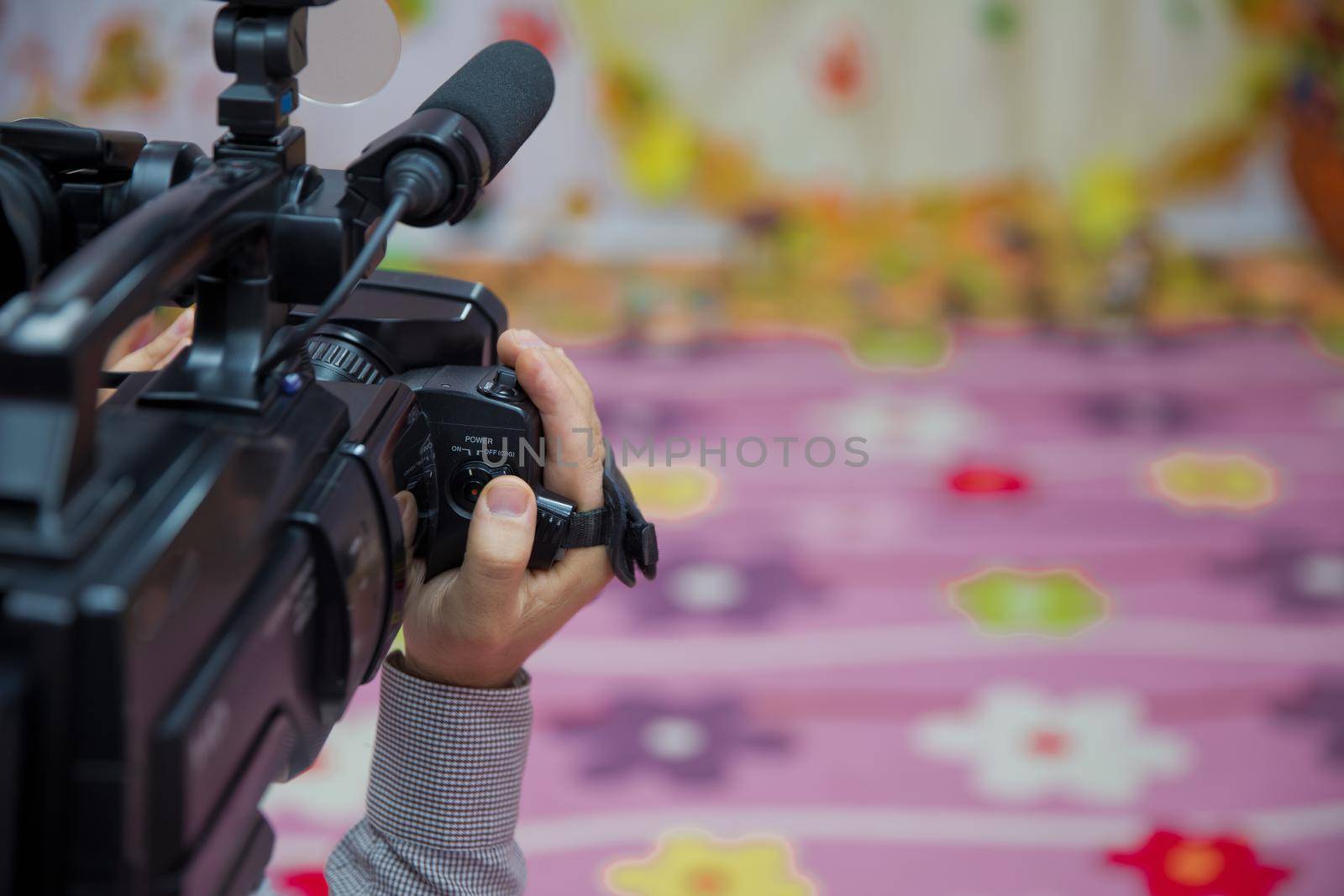 Hand control Video camera operator camcorder working with his equipment outdoor with blurred background . Close up short of video camera operator working with his equipment - Image by Adil_Celebiyev_Stok_Photo