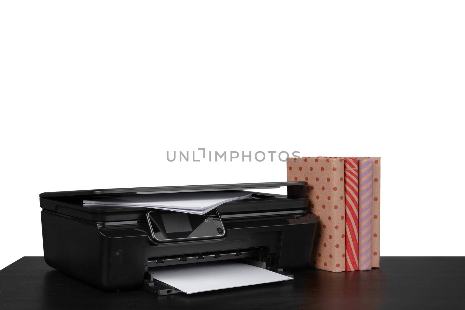 Office table with laser printer and books against white background, close up