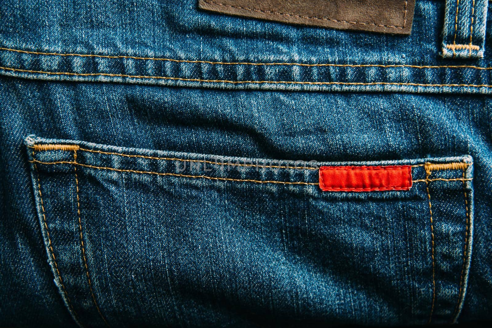 Pocket of blue jeans denim pants closeup.