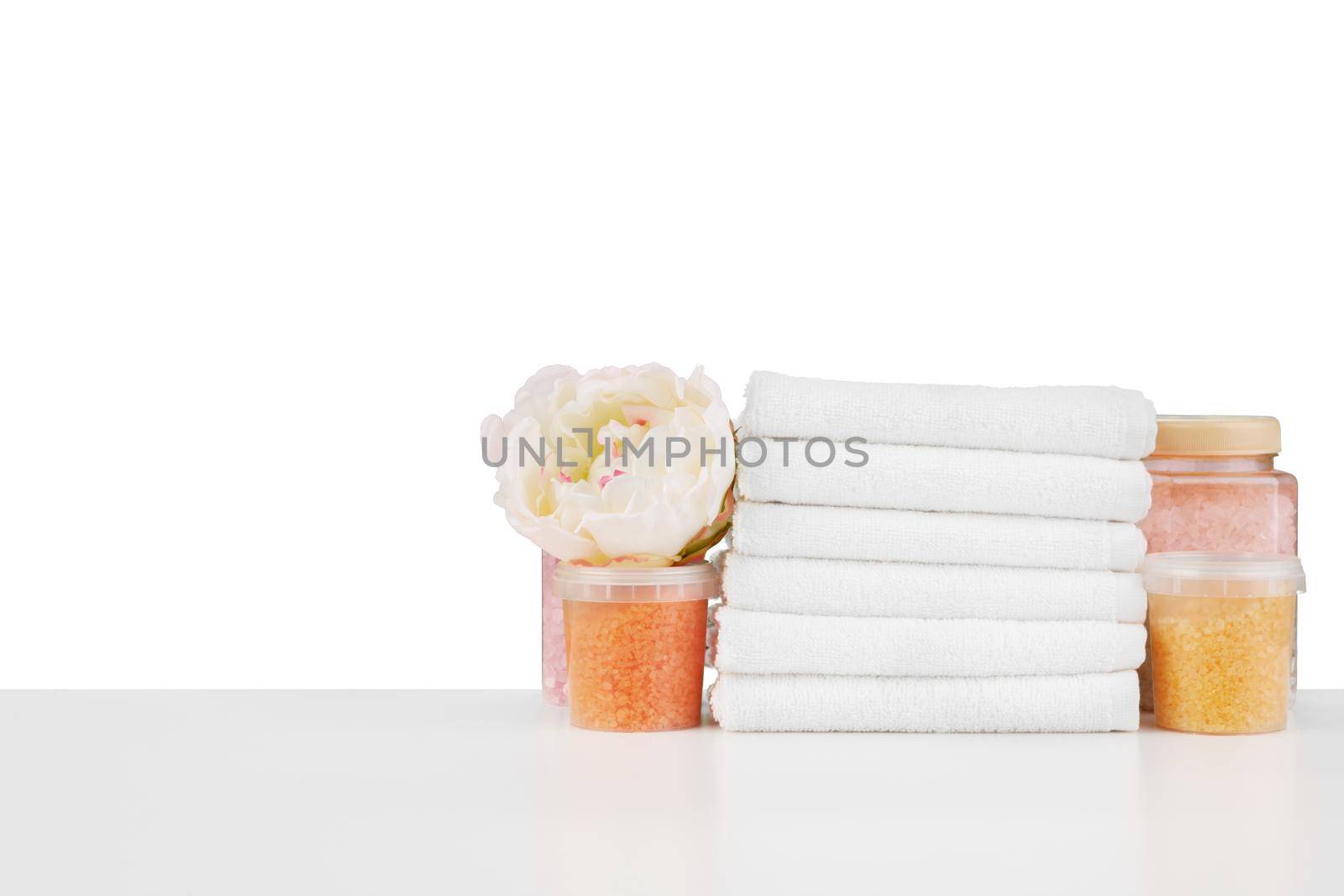 Composition of cosmetic bottles and towels isolated on white background