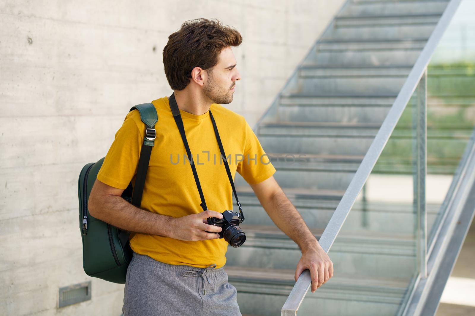 Millennial man taking photographs with a SLR camera by javiindy