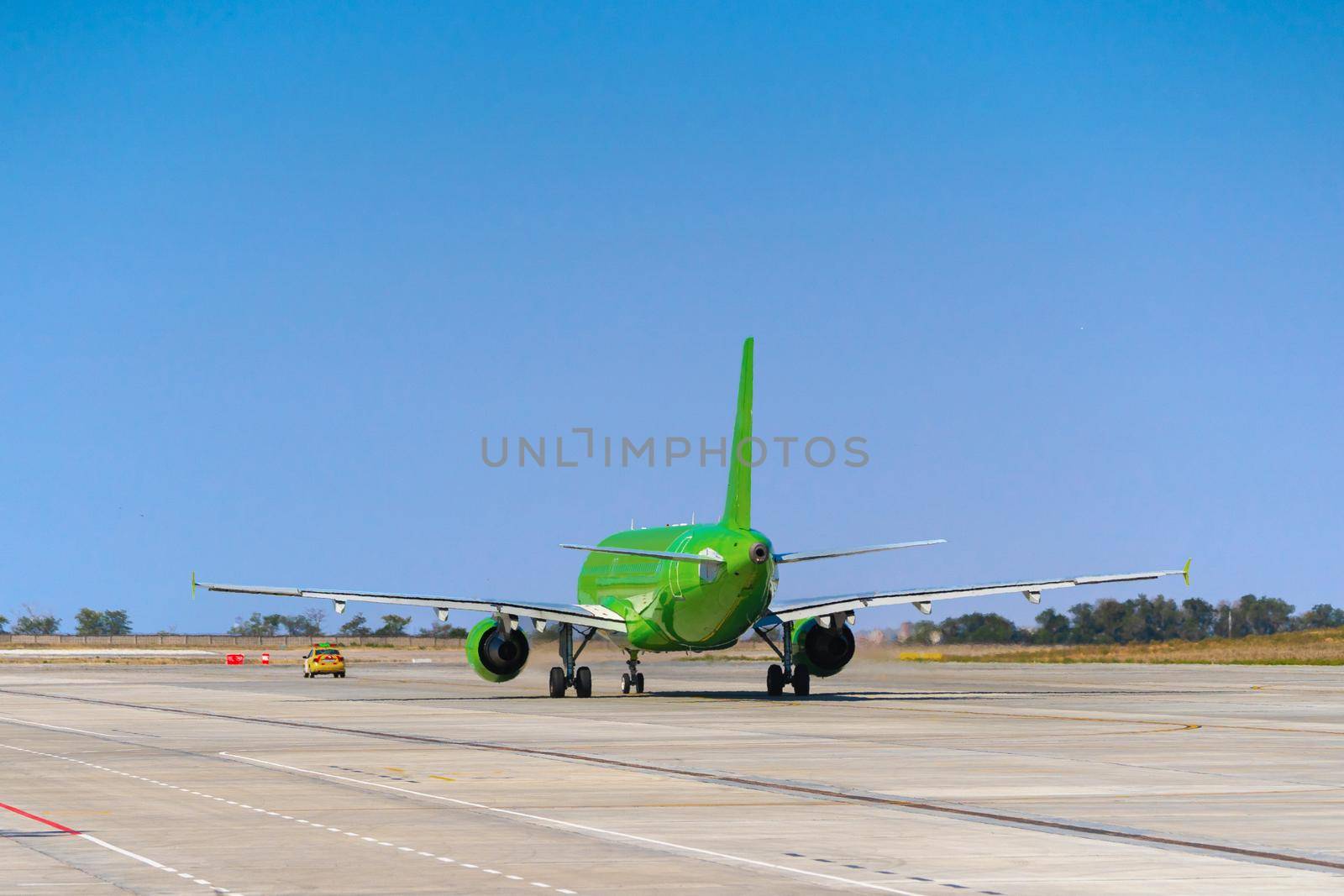 Green passenger airplane at the airport on sunny day photo