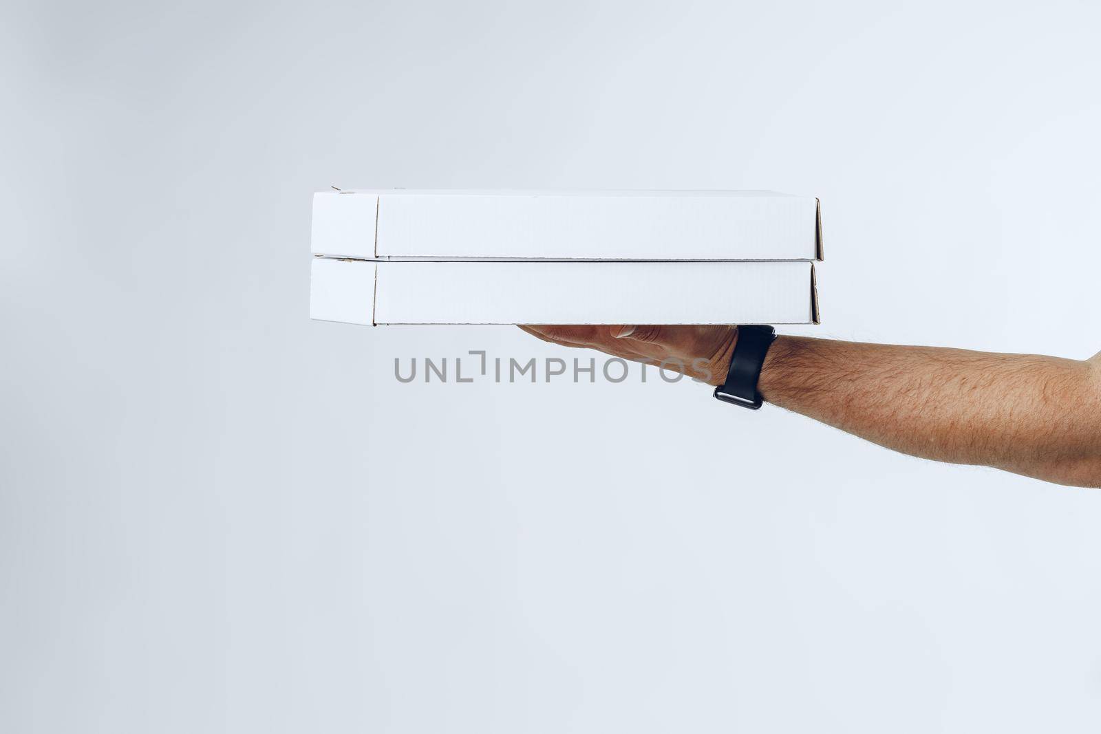 Courier hands giving packed food delivery close up against grey background
