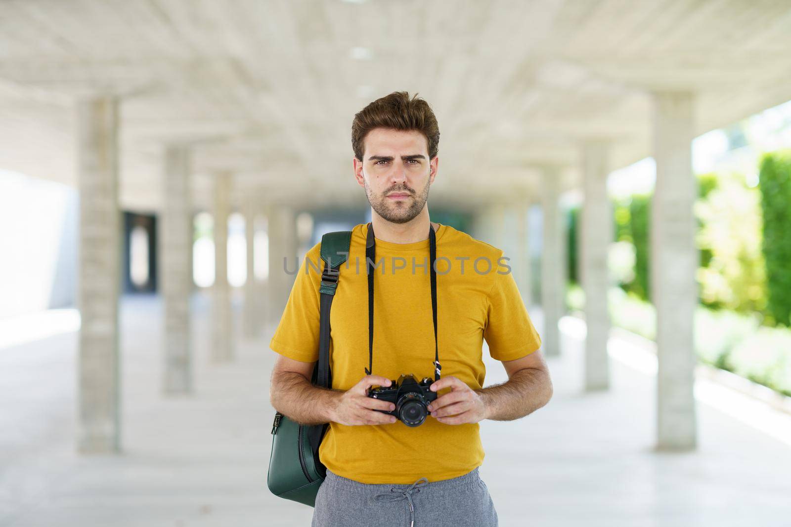 Millennial man using a SLR camera outdoors