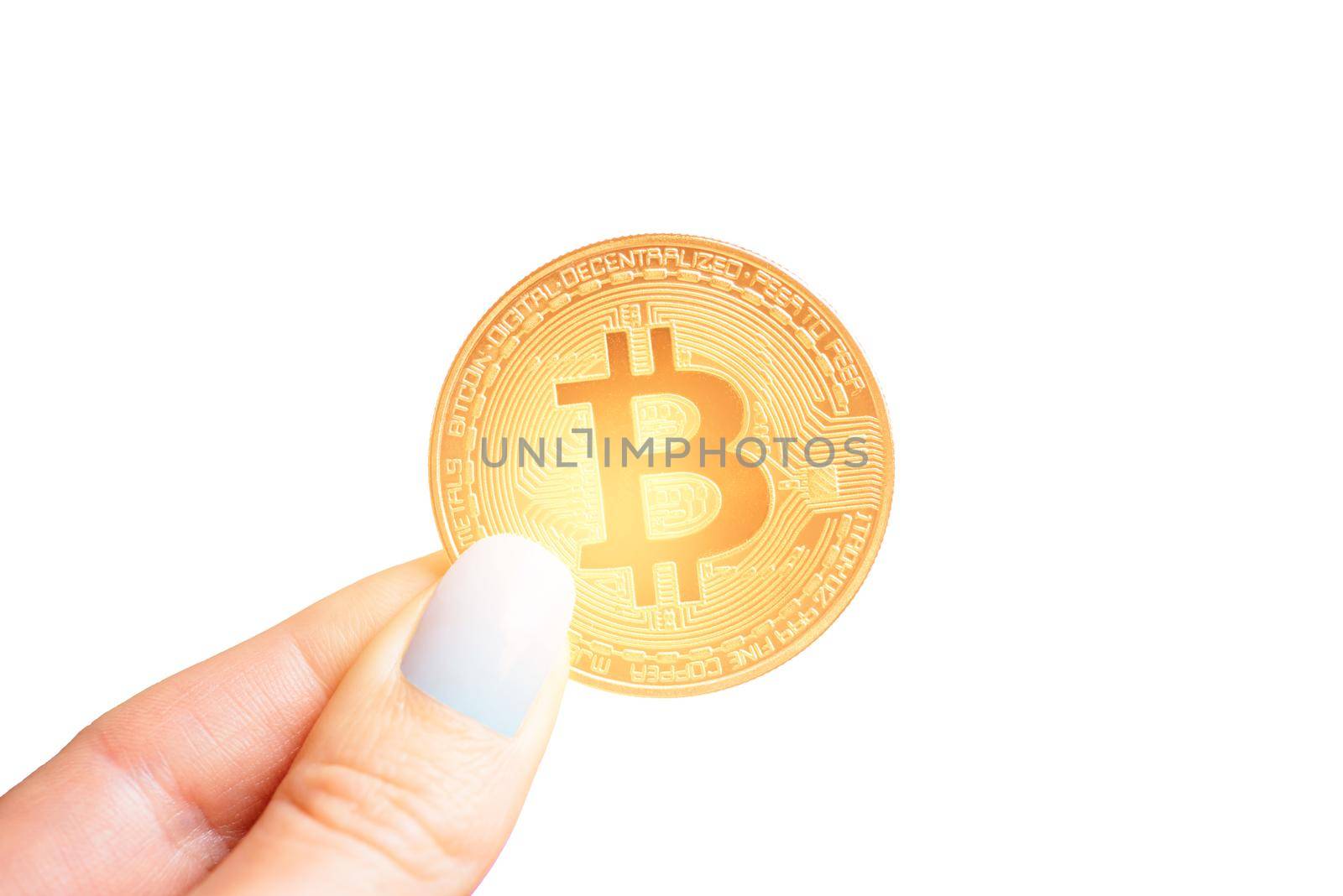 Female hand holding glowing gold bitcoin on a white background, close-up.