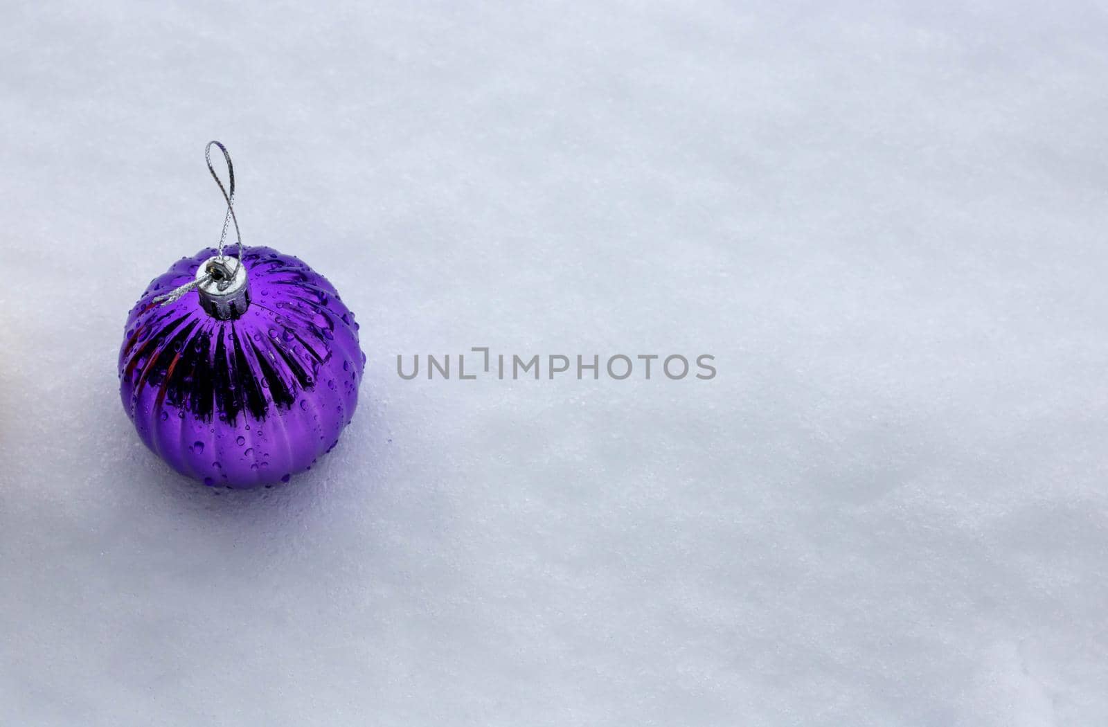 Christmas ball on white snow, the concept of winter holidays.Space for your text.