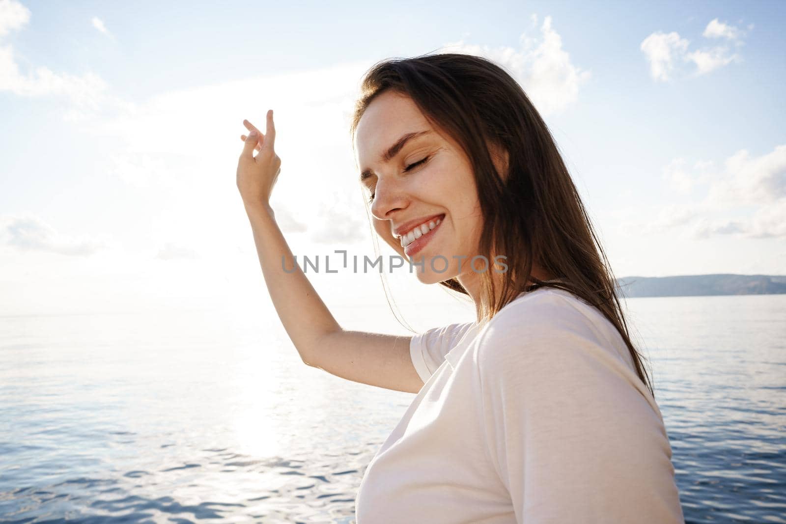 Portrait of young beautiful woman standing on boat against sea backgorund, close up