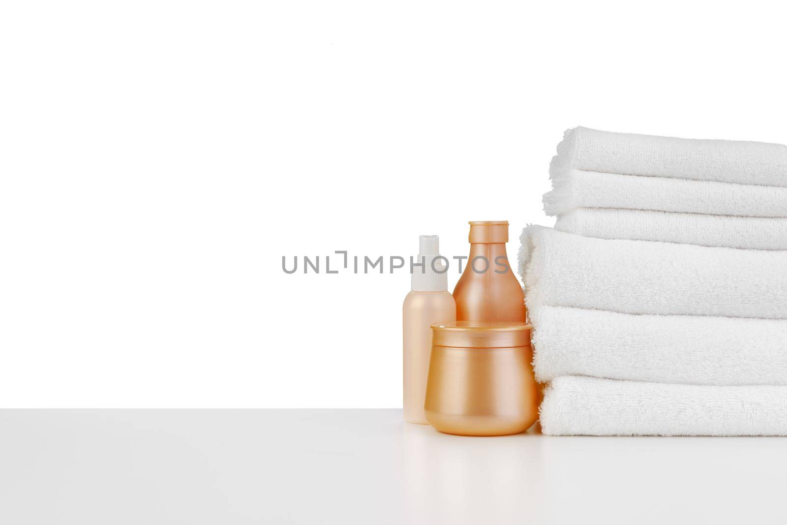 Composition of cosmetic bottles and towels isolated on white by Fabrikasimf