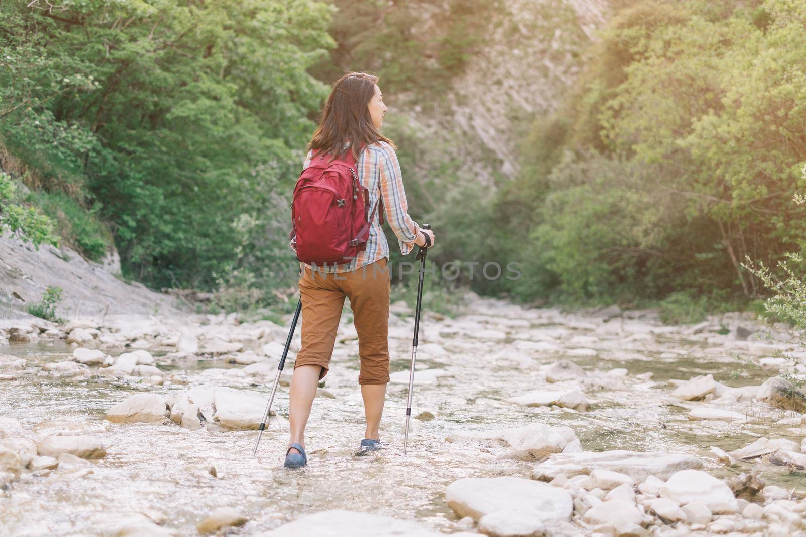 Hiker woman walking along the river gorge. by alexAleksei