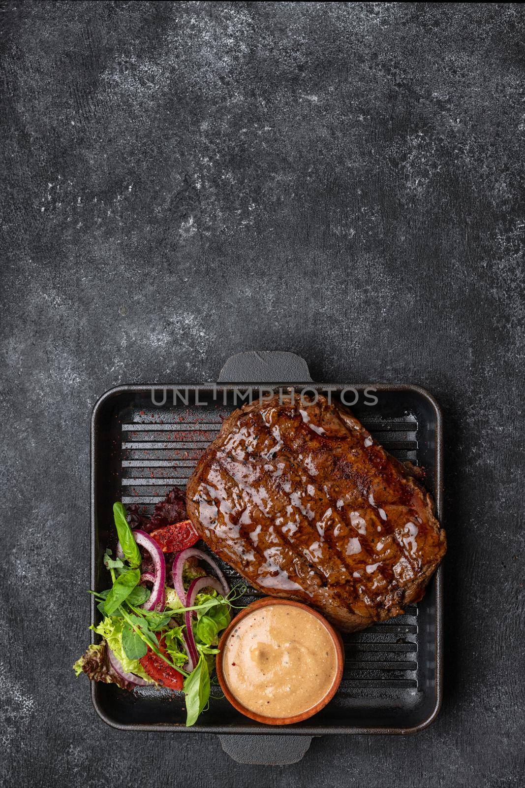 steak with salad and sauce on a blackboard