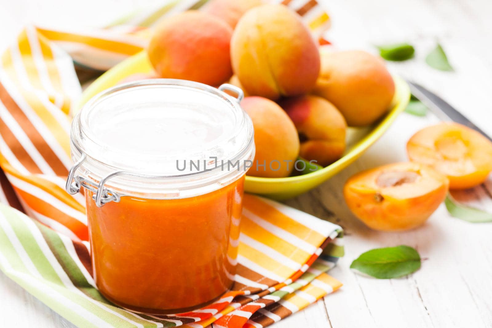 Fleshy apricots in the bowl and fresh jam in a jar