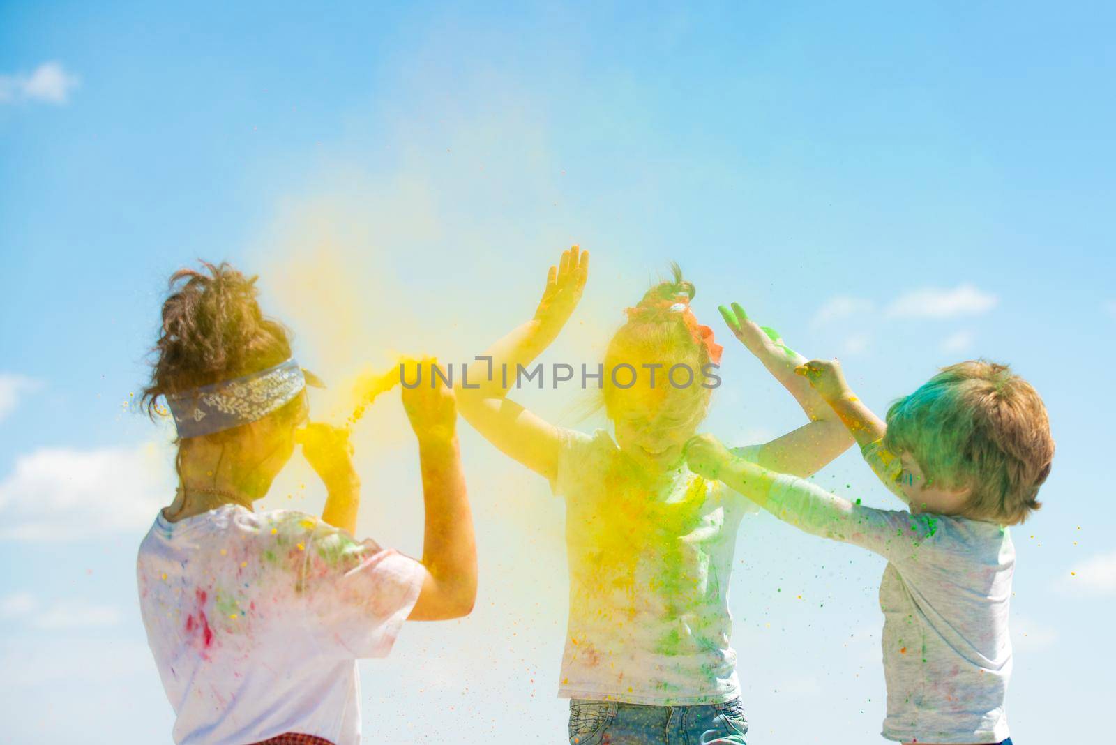 Colored splash powder. Little toddlers kids with dirty face from color holi, smiling and looking up