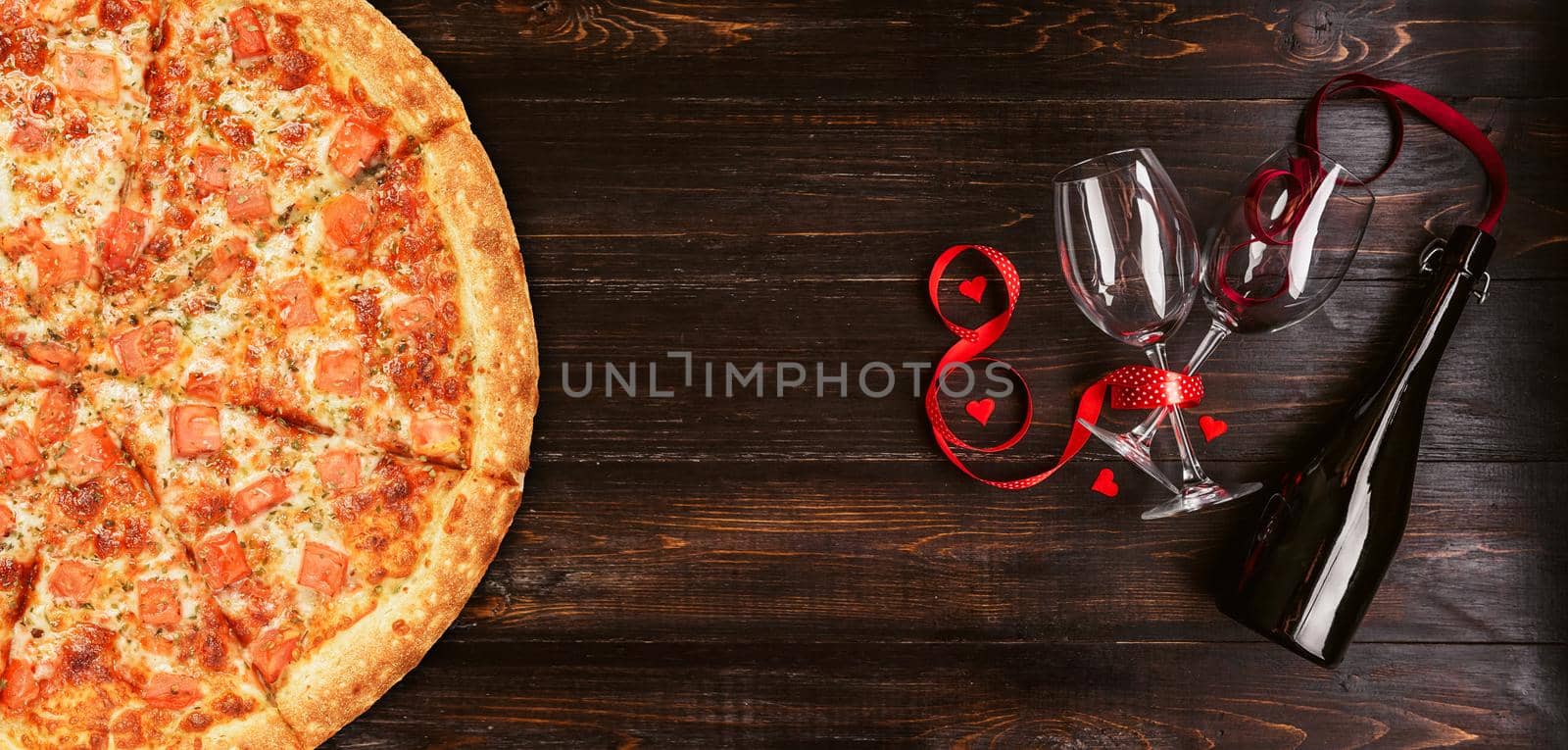 dinner for two in honor of Valentine's Day with pizza and wine.