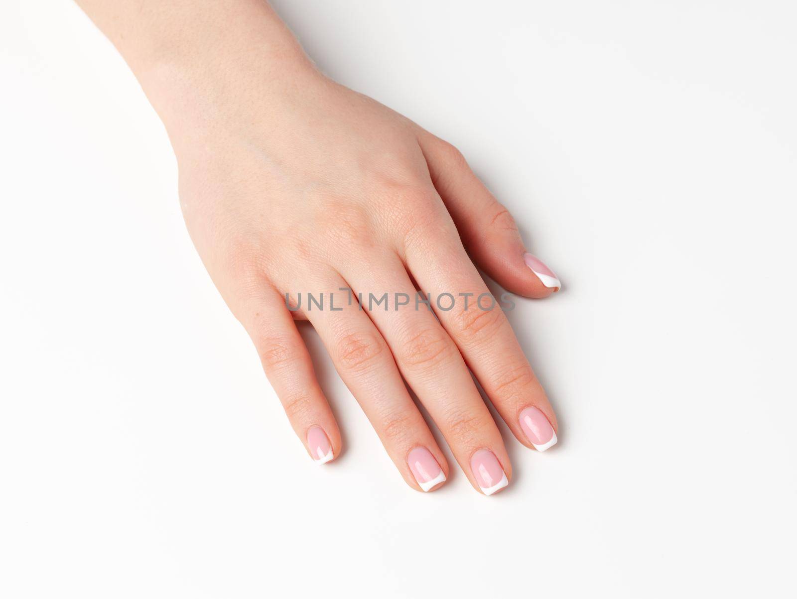 Beautiful female palm with french manicure on white background