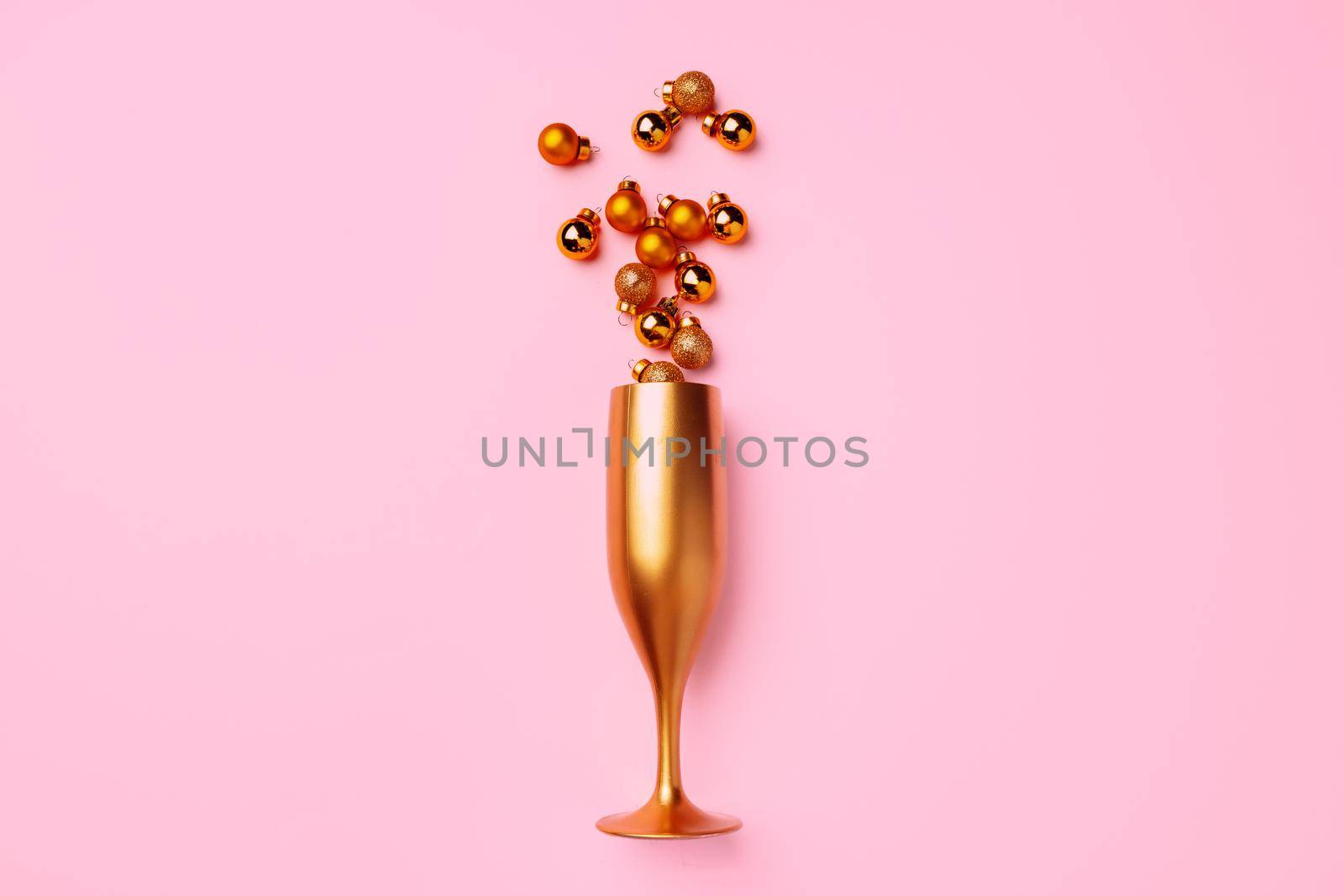 Champagne glass with Christmas balls flat lay top view
