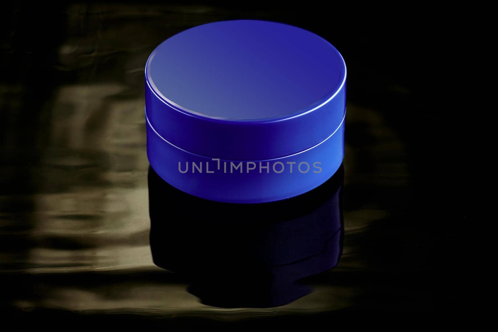 Blue plastic jar in water on a dark background. Layout for advertising cosmetics and body care products. by SergeyPakulin