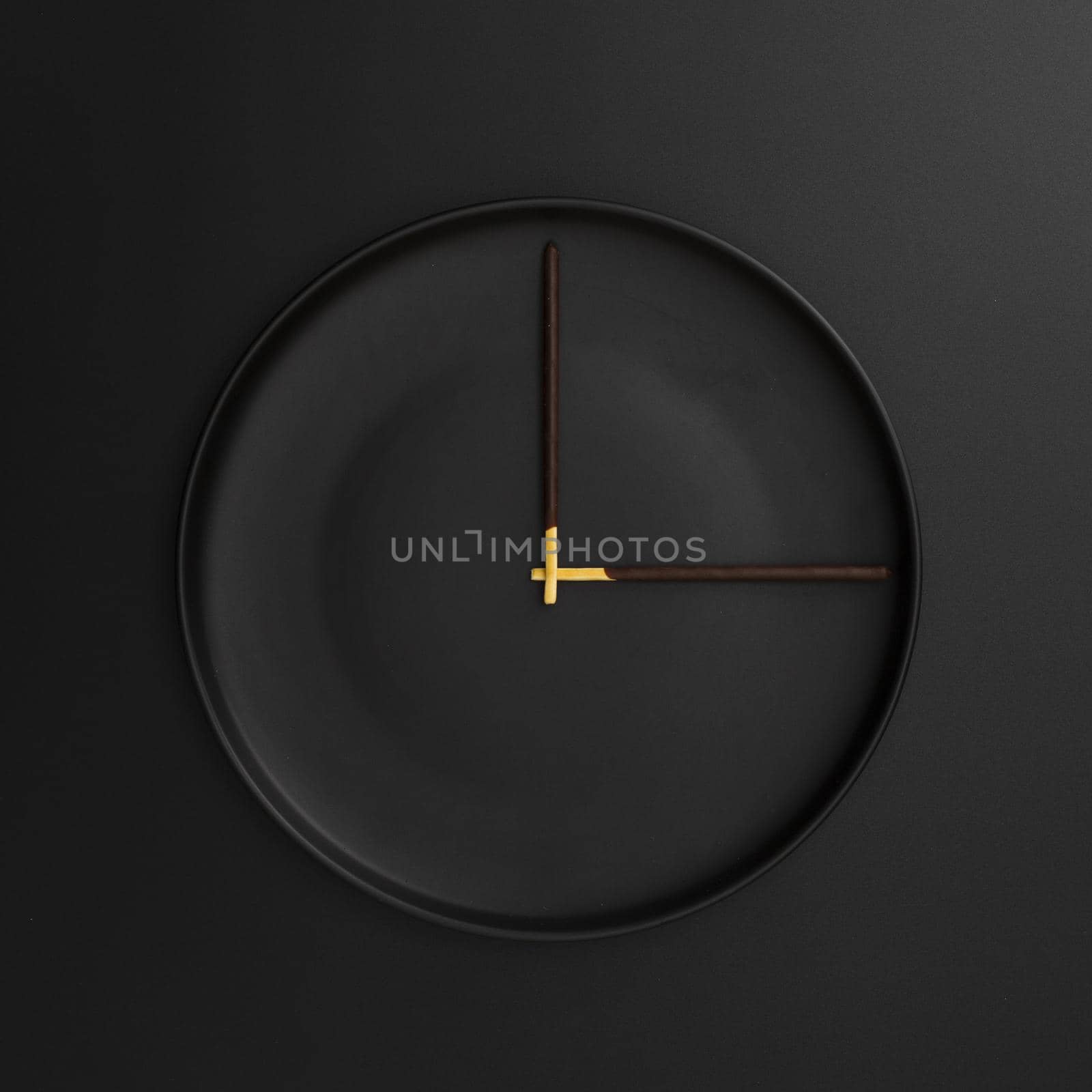 dark plate with chocolate sticks form clock by Zahard