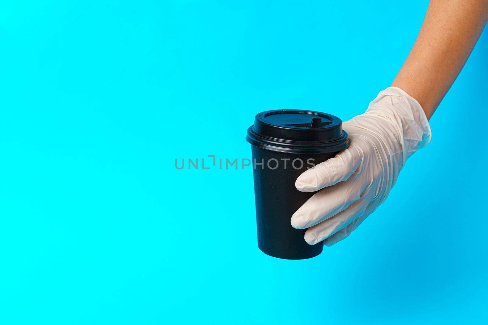Coffee delivery. Human hand holding takeaway coffee cup by Fabrikasimf