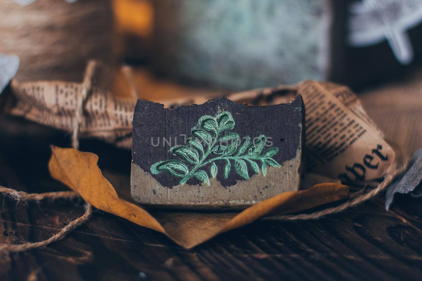 Pieces of beautiful natural handcrafted soap on wooden background with botanical elements, close up view. For relax, health, spa and aromatherapy. Lifestyle.