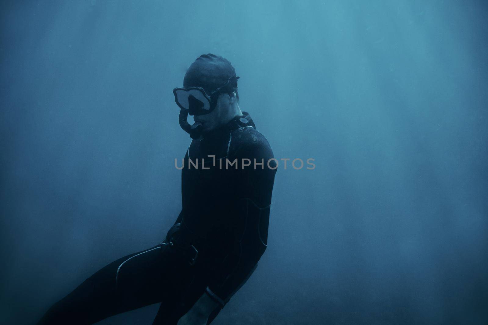 Man diver in wetsuit swimming underwater. by alexAleksei