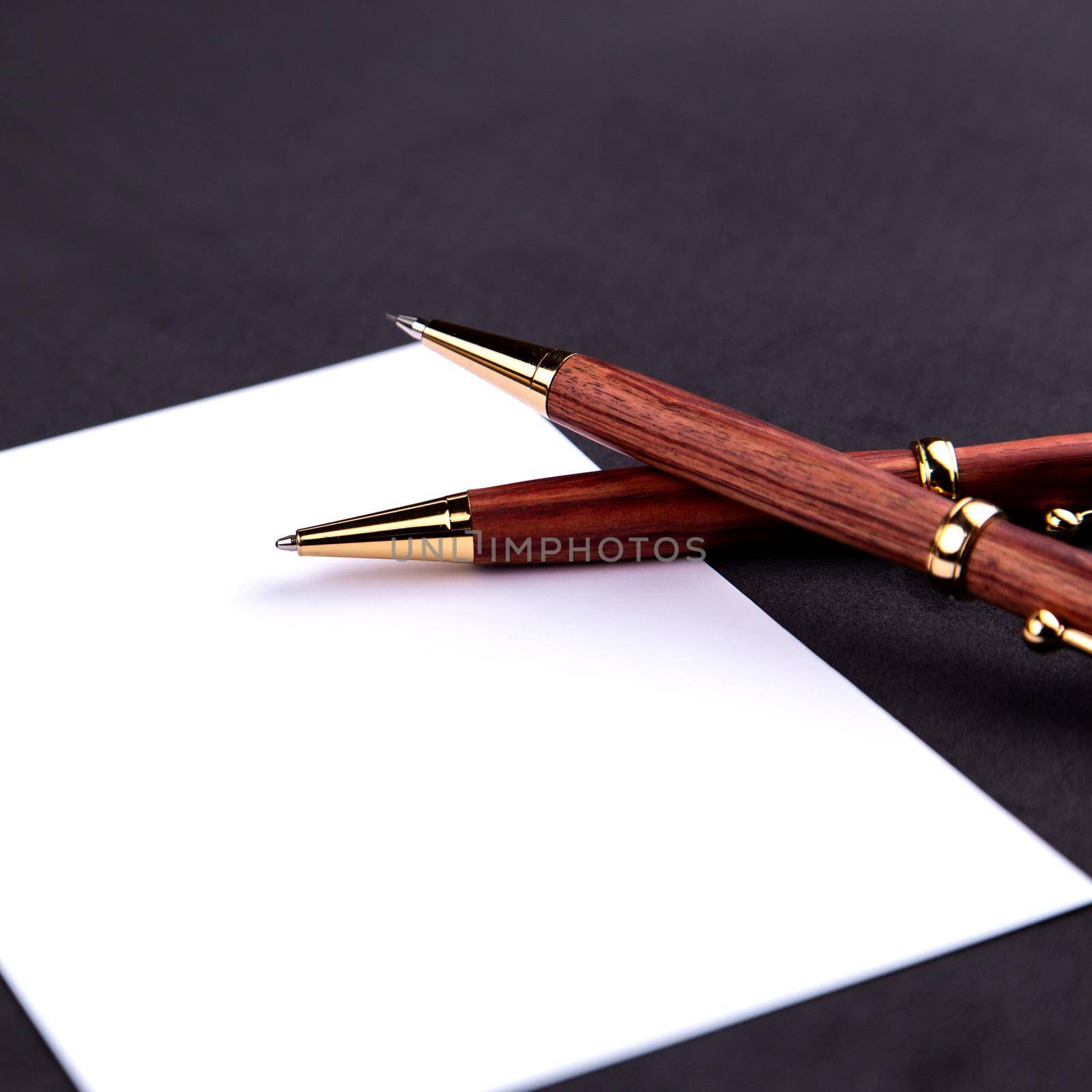 Luxury pen and mechanical pencil in wood and gold with a white sheet of paper by lunarts