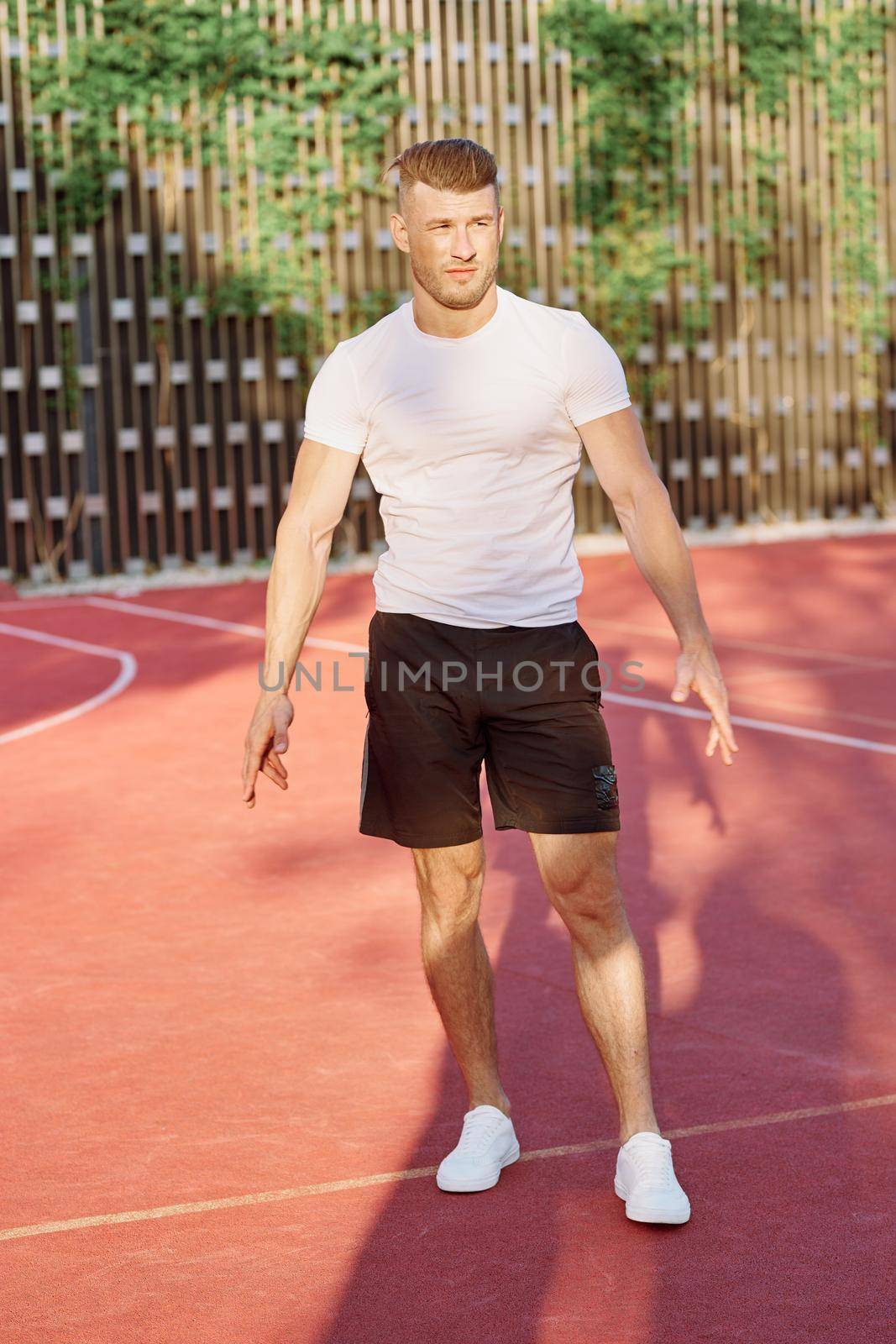 man in white t-shirt on the sports ground workout motivation. High quality photo