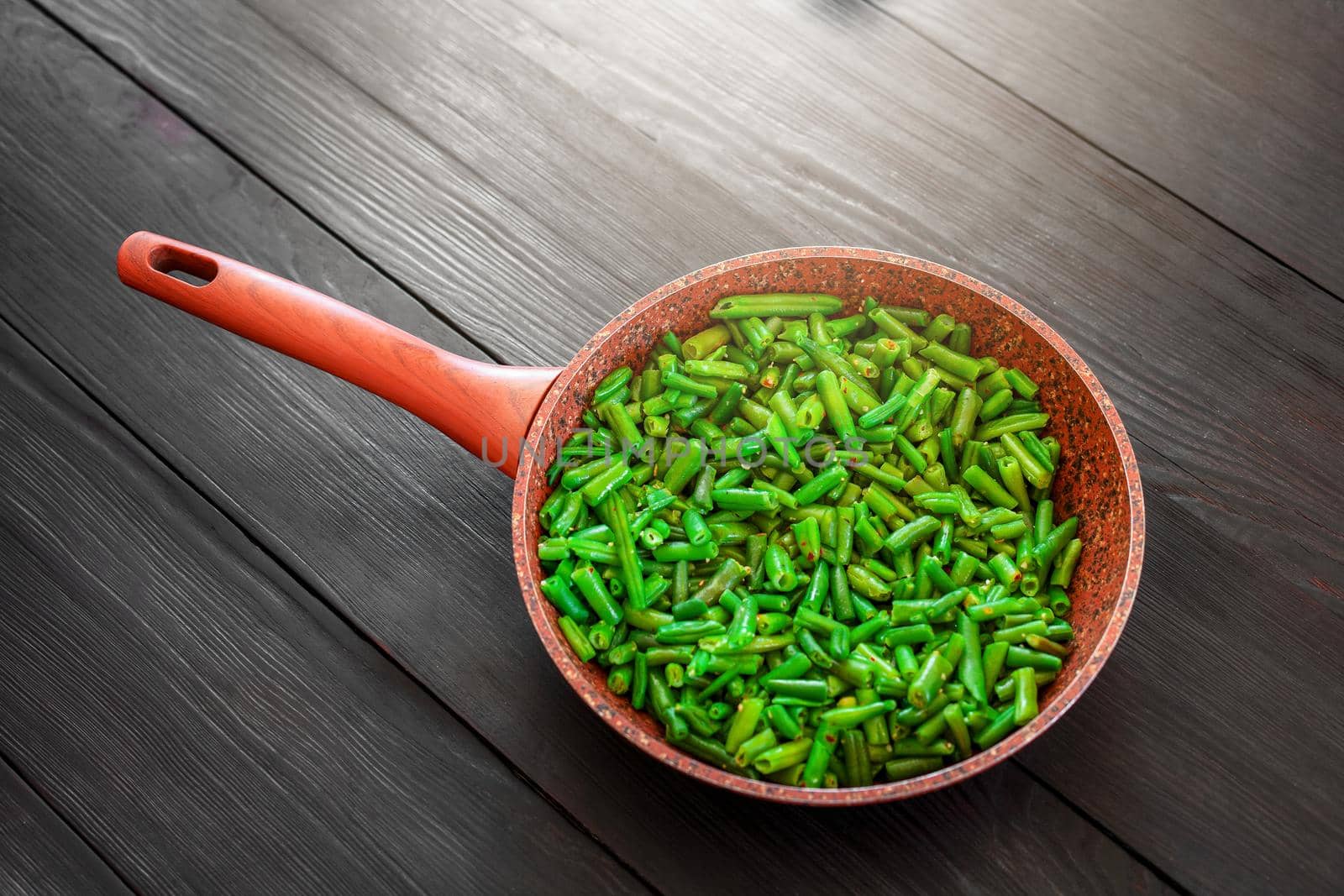 Vegetarian food. Fried string beans in a pan. Stylish background for design. Minimalism. Healthy food from vegetables