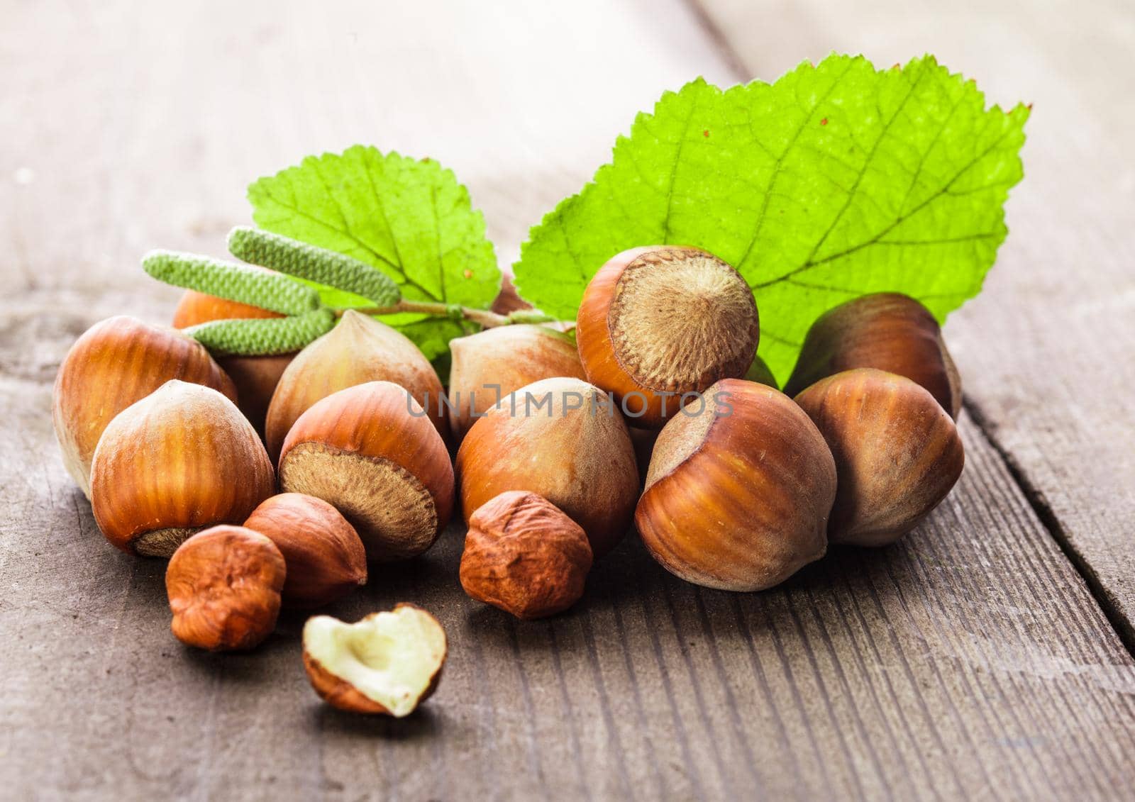 Hazelnuts with shell and green leaf on the wooden table