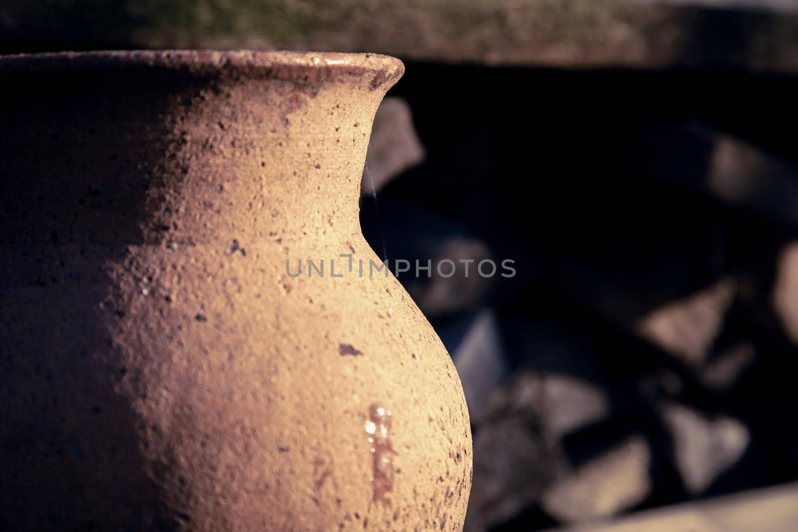 Ancient clay jug close-up outdoors on a sunny day.