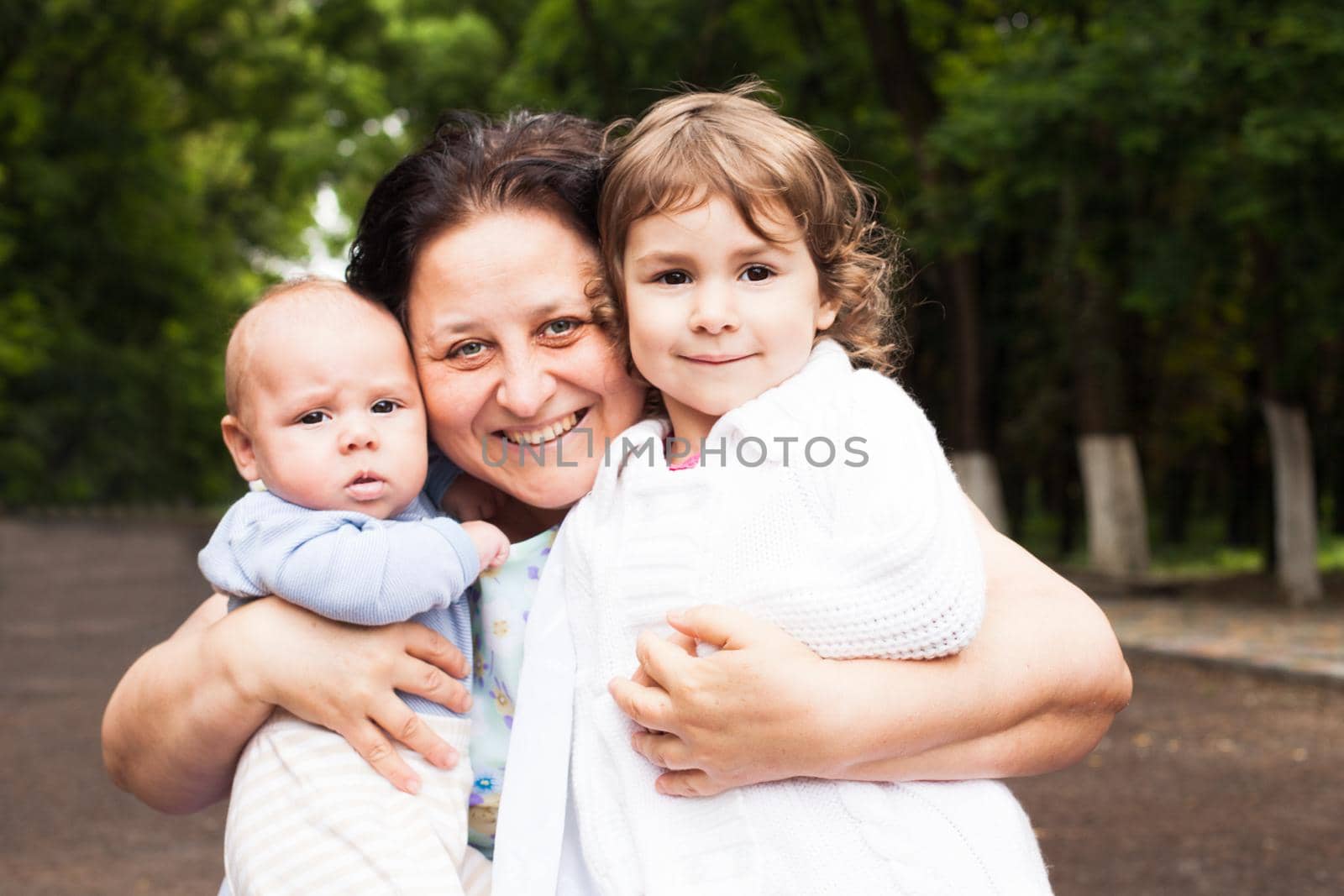 Grandmother with her grandchildren in a park. Family portraits