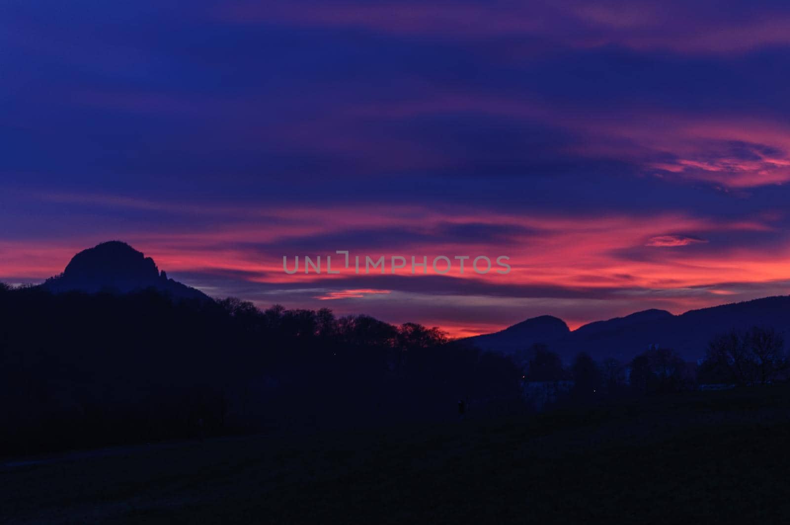 Sunset over Mountains. Night dark blue and pink sky and silhouette of mountain.