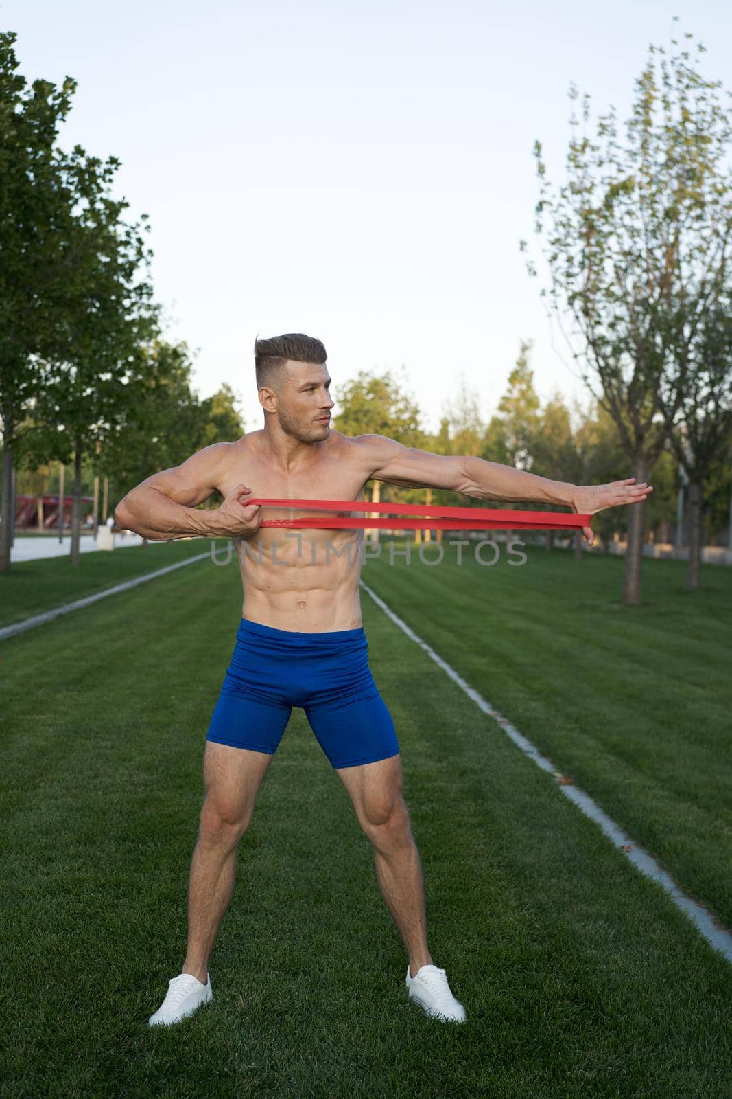 sporty man in blue shorts in the park exercise fitness. High quality photo