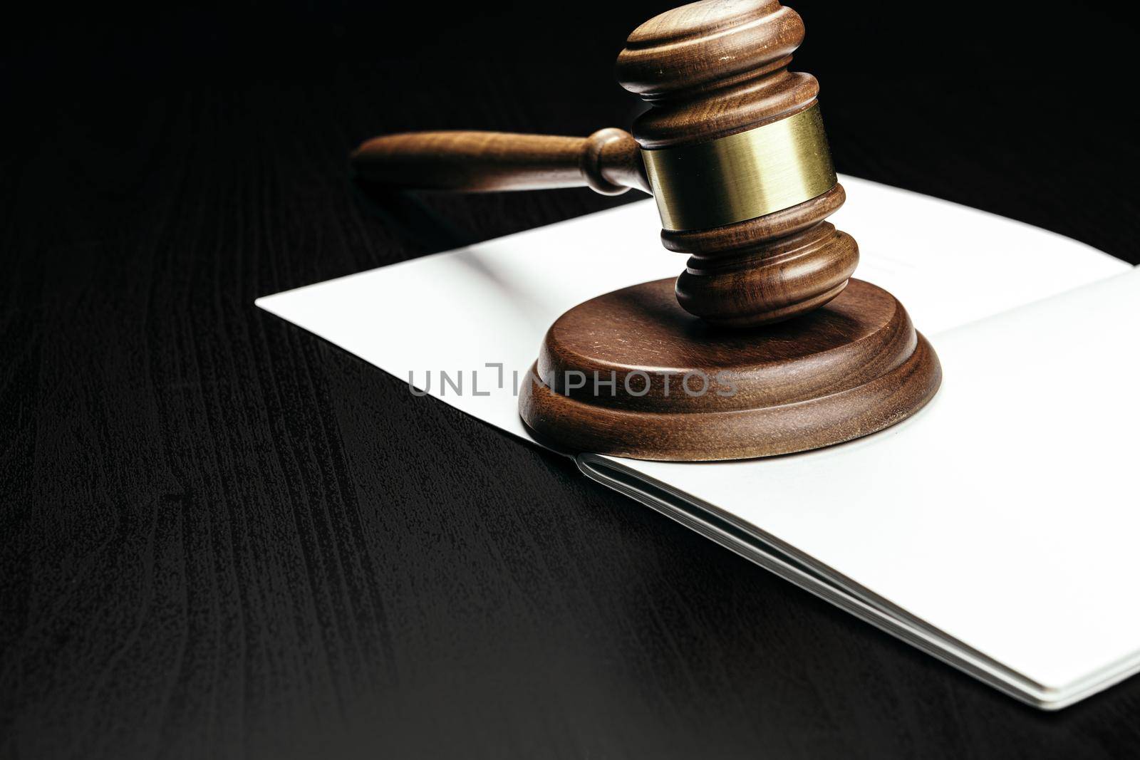 Judge's gavel on wooden table in dark. High quality photo