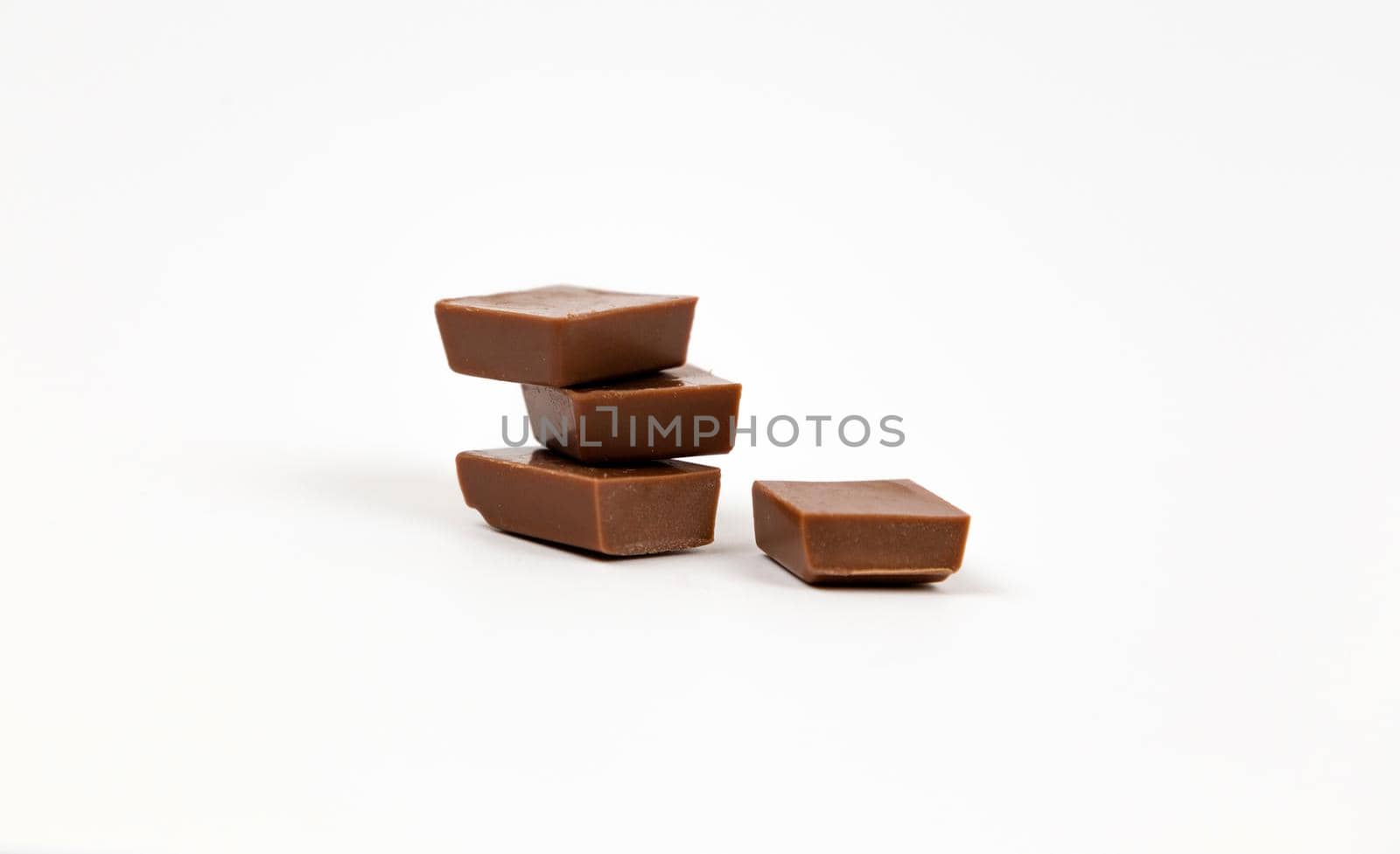 Macro photo of Chocolate bar. Broken pieces over white background.