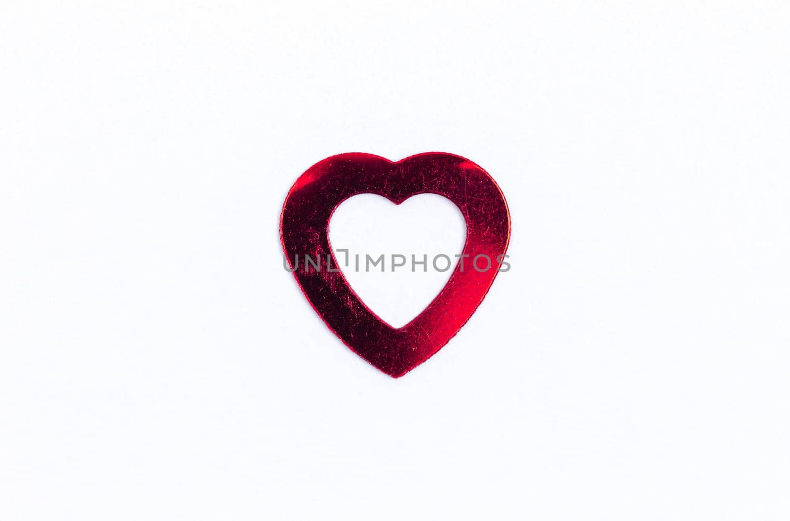 Red paper Valentines Day heart against a white background.