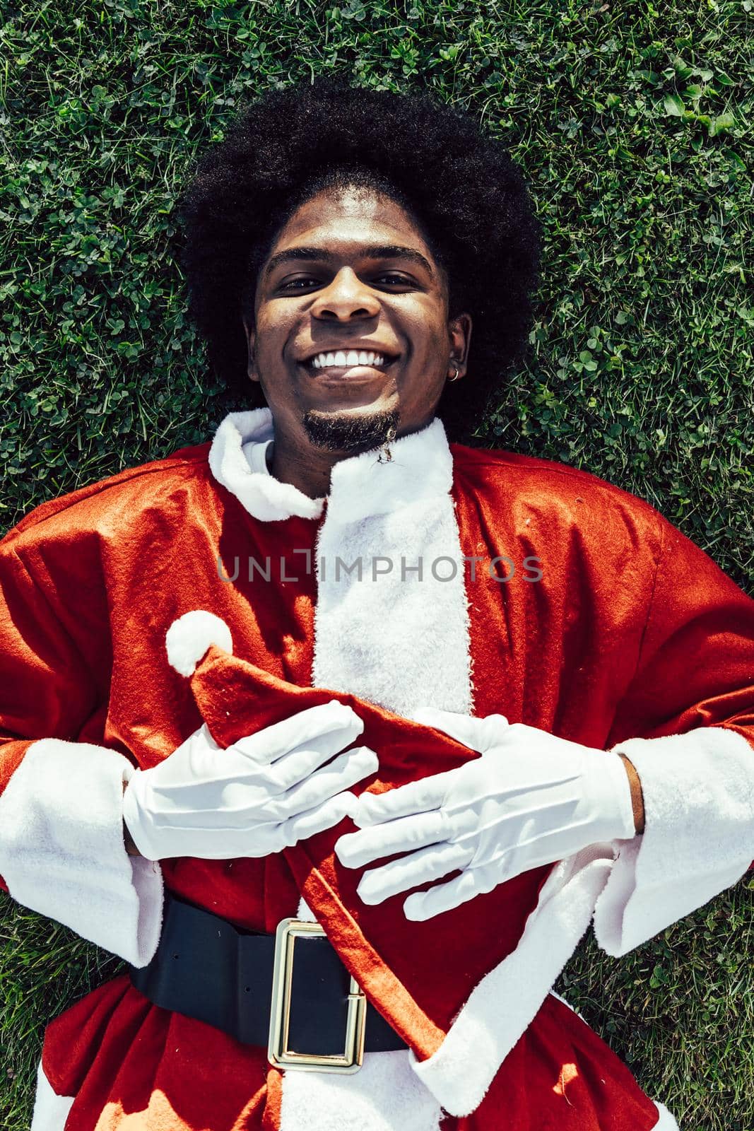 close-up of afro santa claus lying on the grass