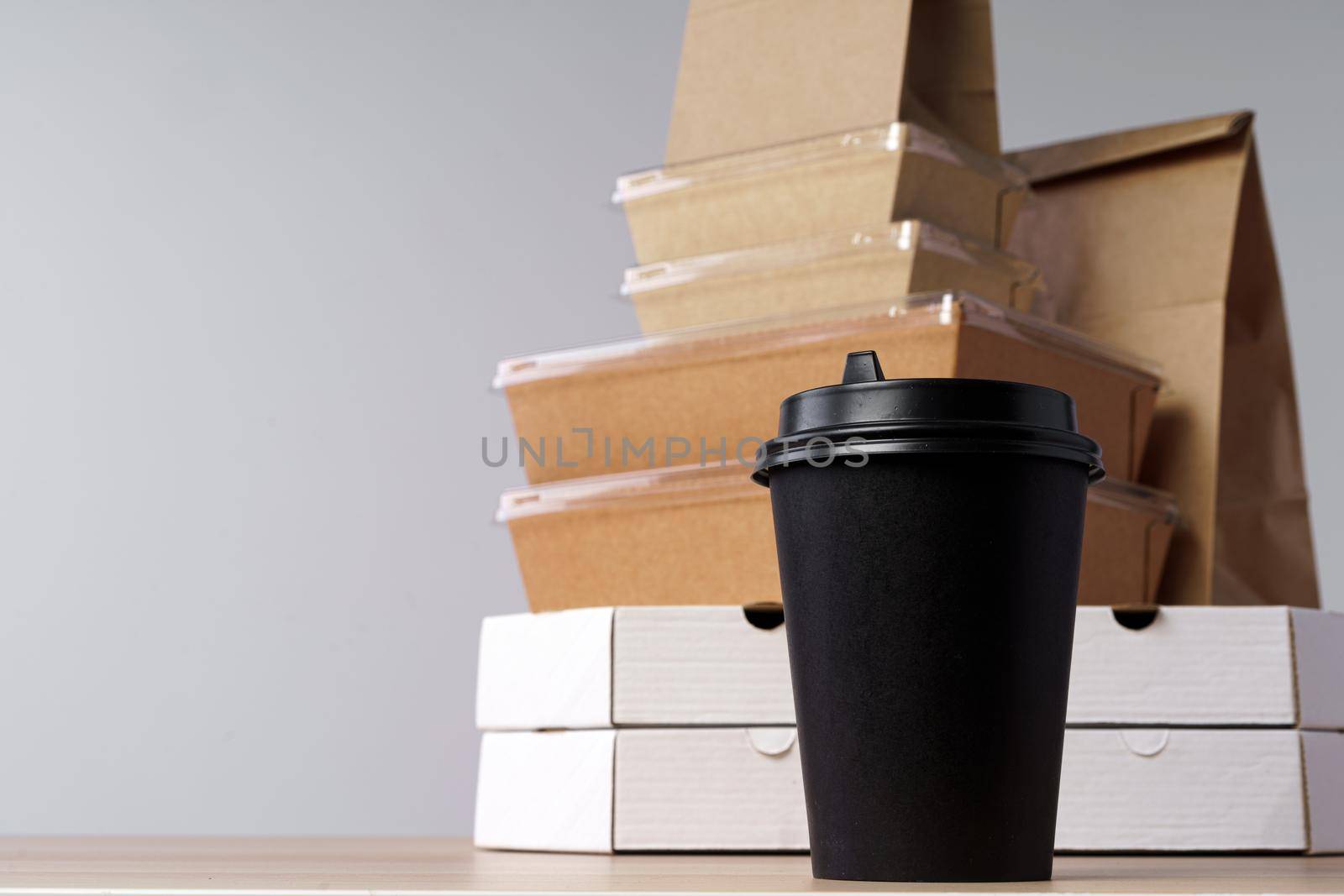 Many various take-out food containers, pizza box, coffee cups and paper bags on light grey background. Food delivery