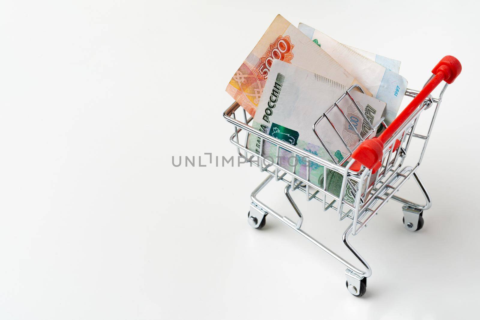 Toy shopping cart with Russian rubles money. Living wage and purchasing power concept. High quality photo
