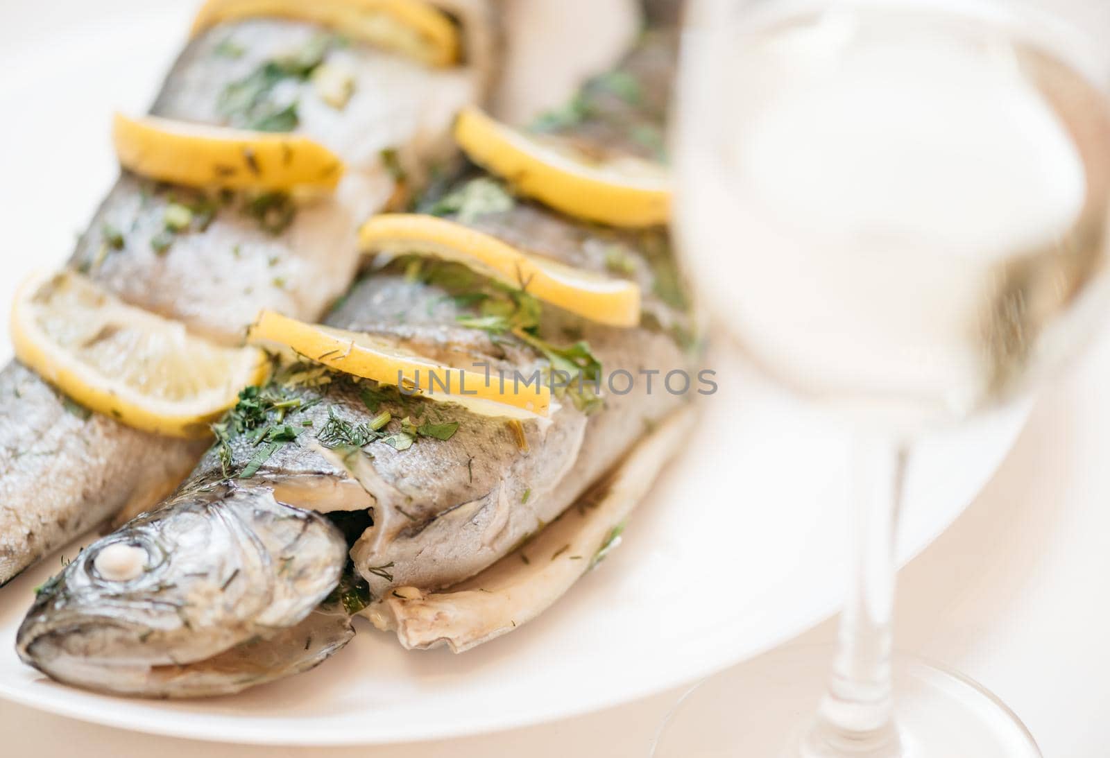 Fish dish with glass of white wine for dinner. by alexAleksei