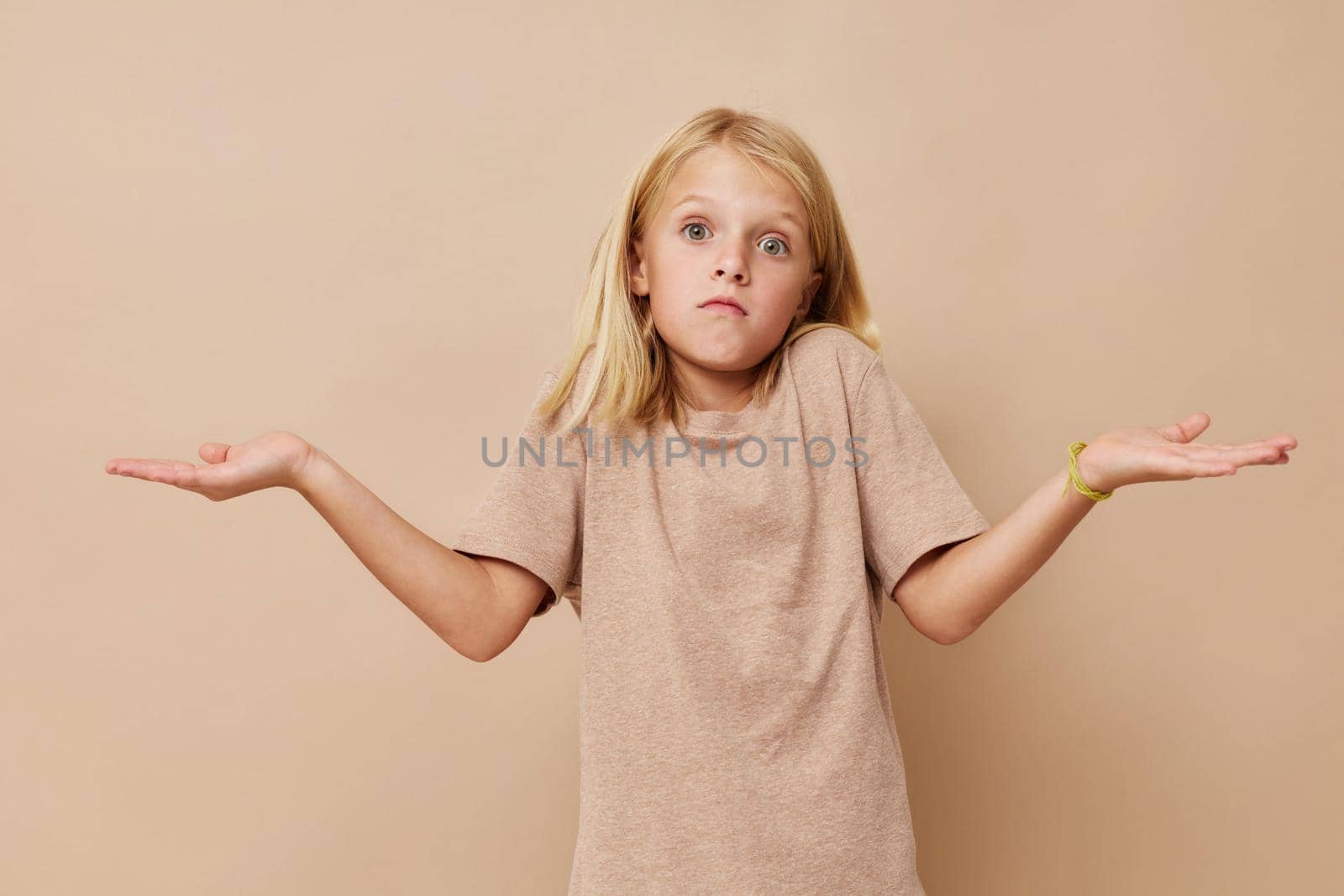 Positive little girl gestures with his hands isolated background by SHOTPRIME
