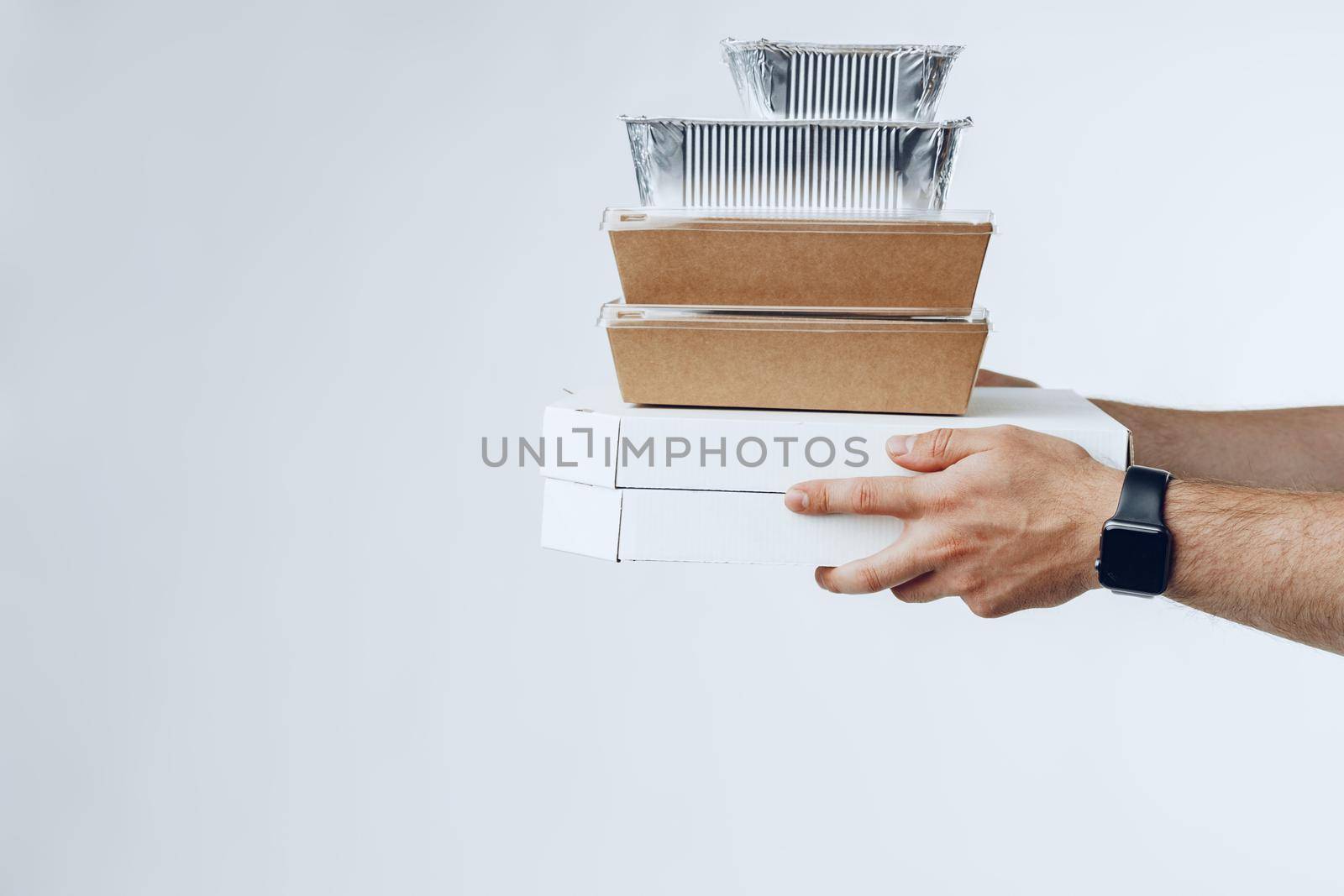 Courier hands giving packed food delivery close up against grey background