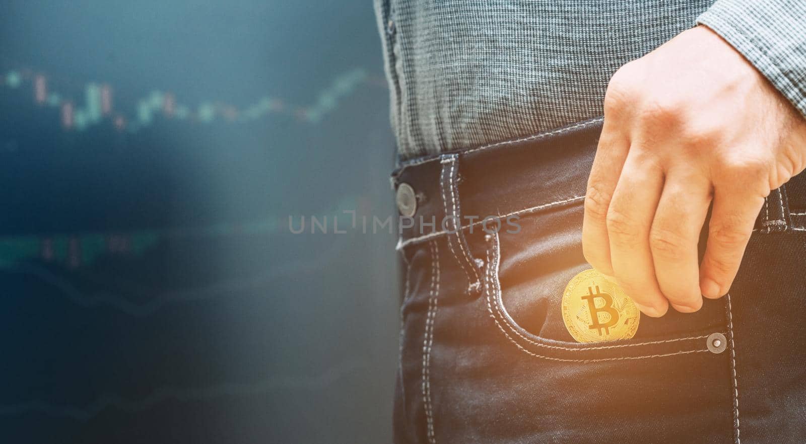 Man holding gold bitcoin and putting into pocket. by alexAleksei