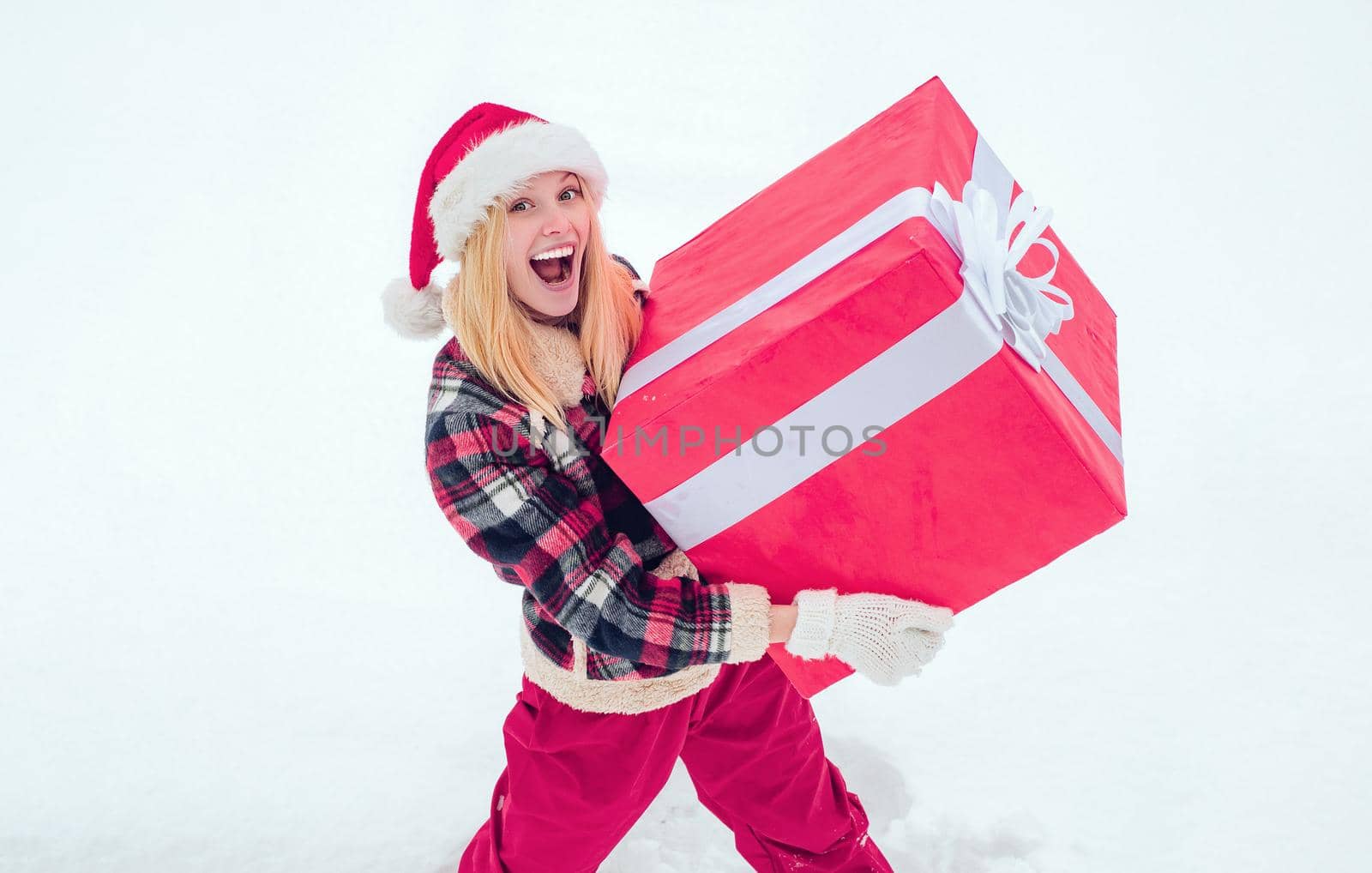 Winter woman with gift. Portrait of Santa woman with huge red gift looking at camera. Christmas Woman holding a huge gift box. Lottery winner. Christmas winter people. by Tverdokhlib