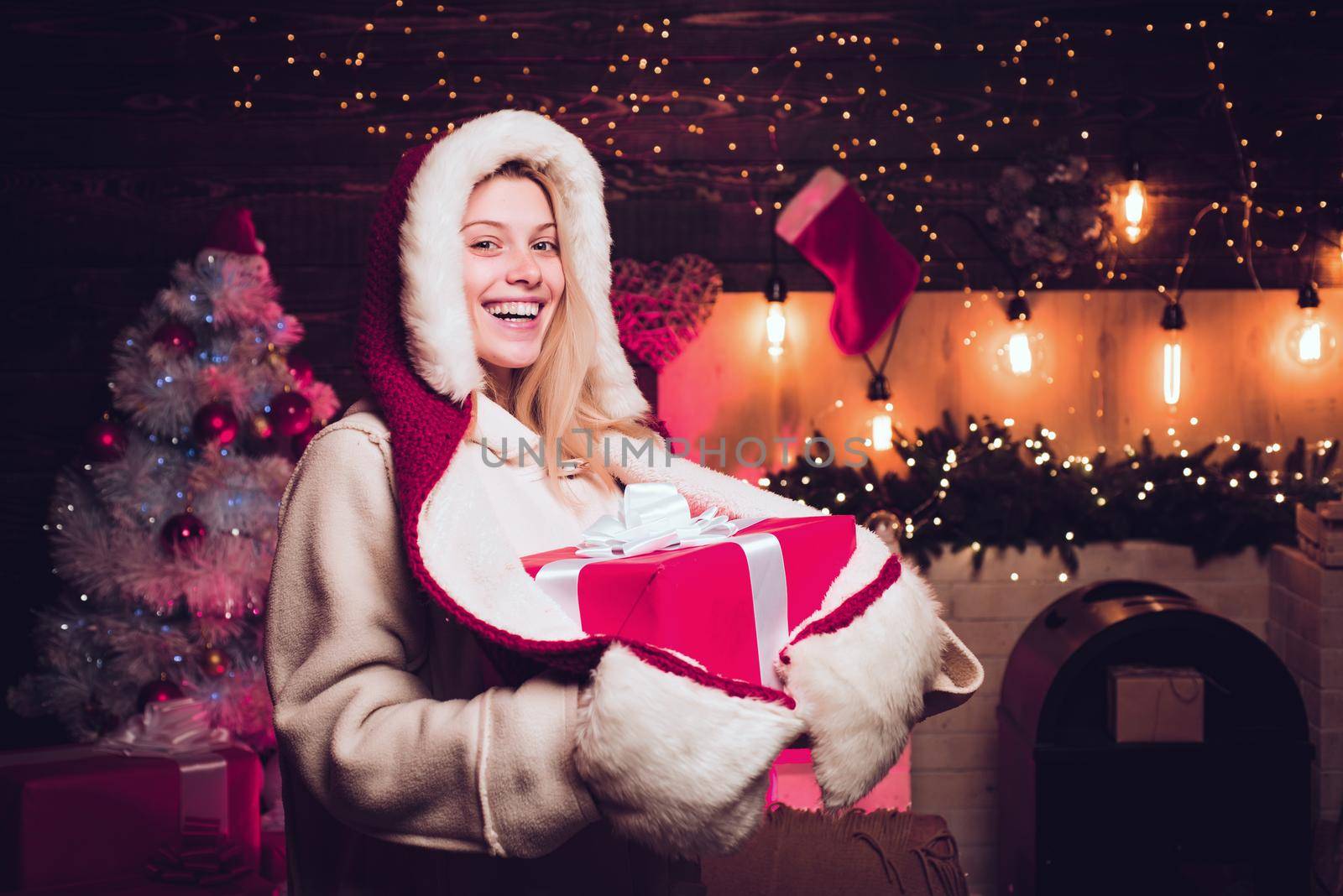 Christmas gift. Santa woman posing on vintage wooden background. by Tverdokhlib