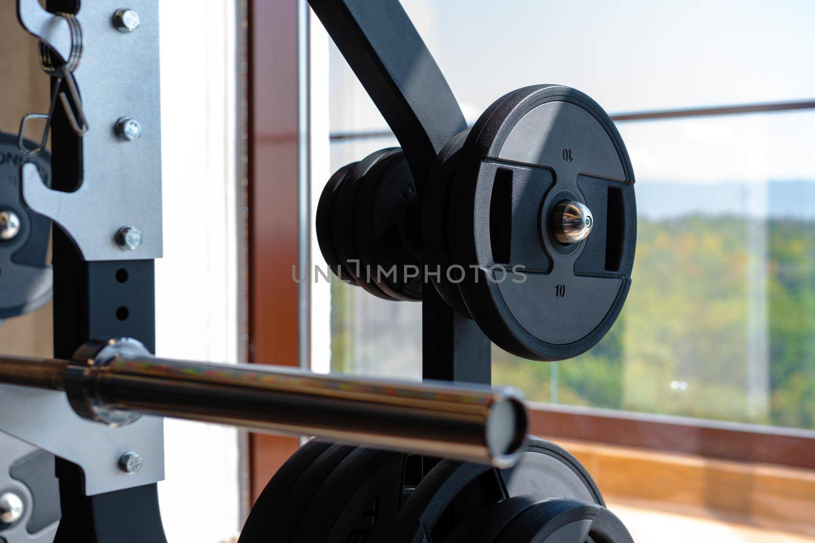 Weight plate on metal barbell in a gym, close up