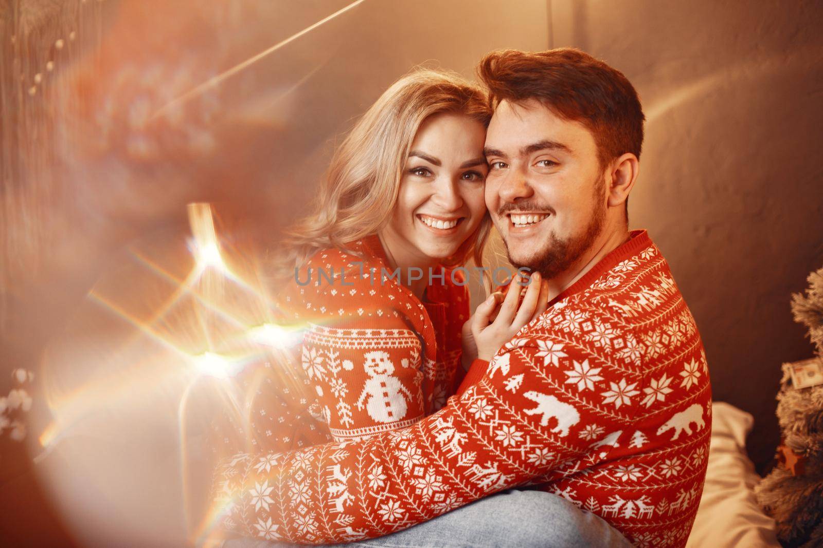 People in a Christman decorations. Man and woman in a red sweater. Family at home.