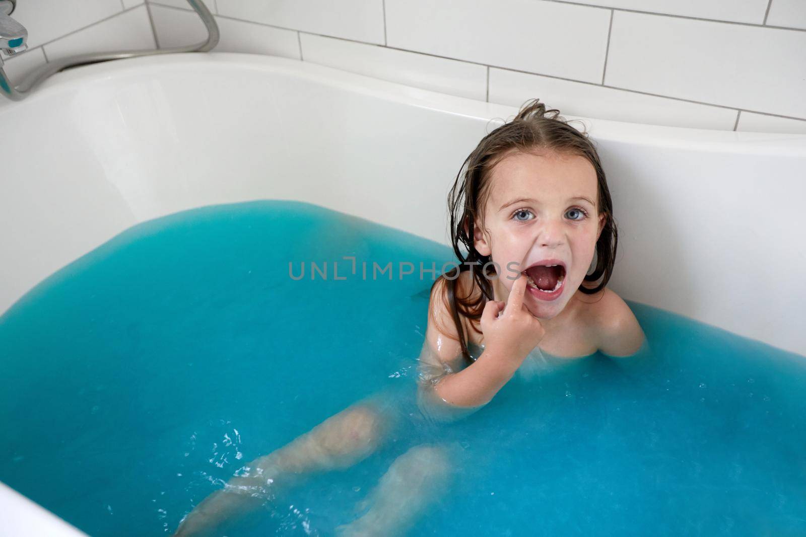 Little girl with mouth opened taking bath in bathtub by Demkat
