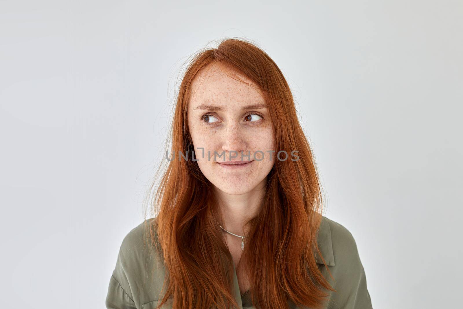 Content redhead woman standing against white wall by Demkat