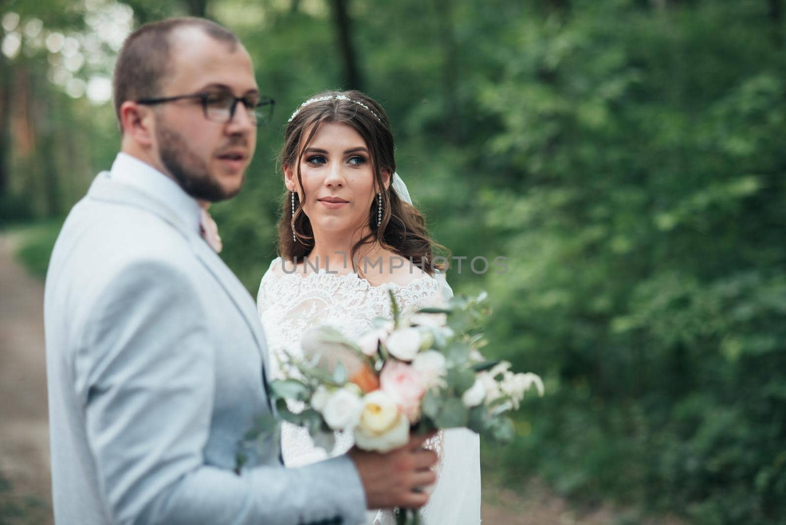 Wedding photo of the bride and groom in a gray-pink color on nature in the forest and rocks. by lunarts