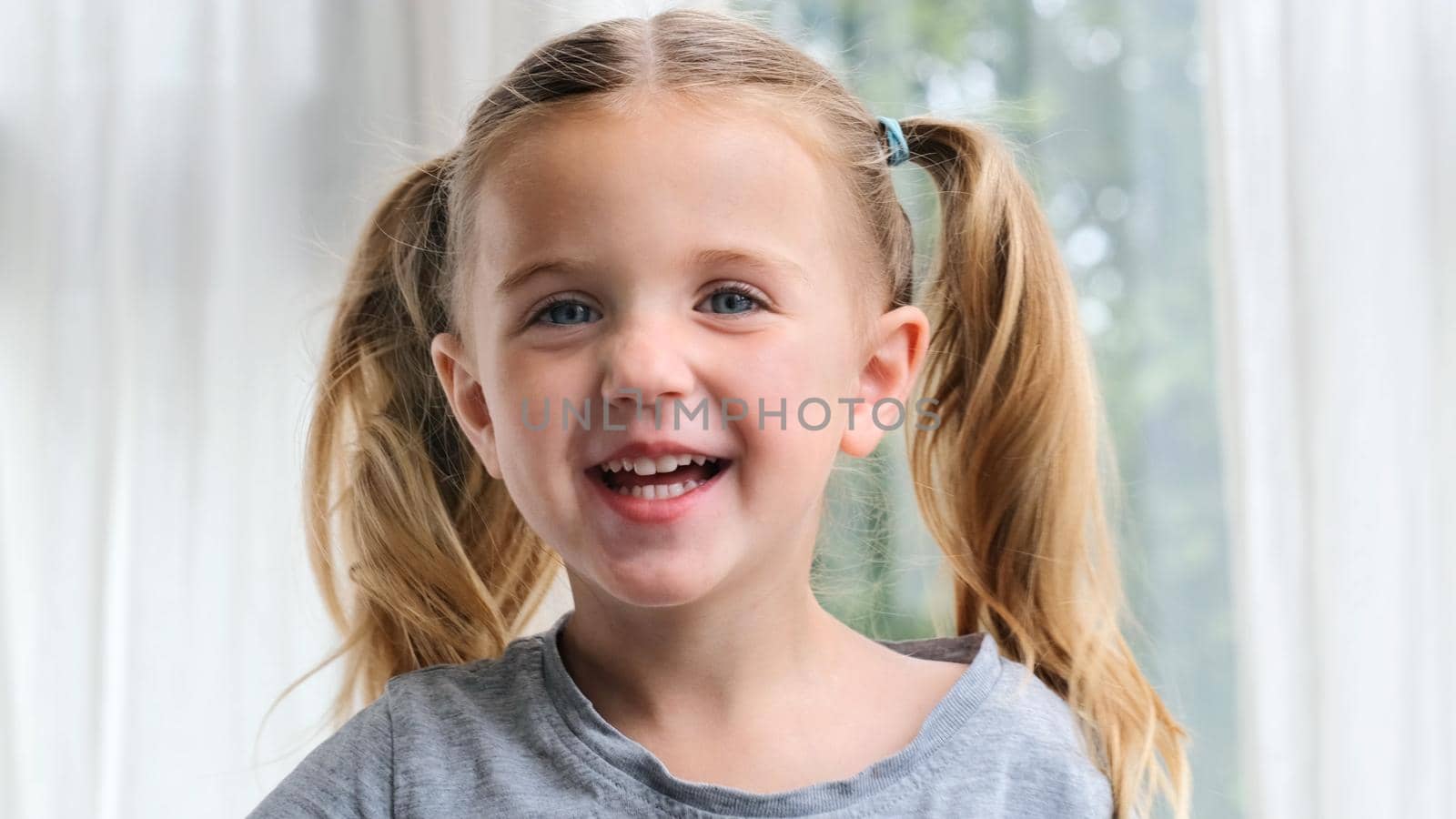 Funny little girl smiling looking at camera at home by Demkat